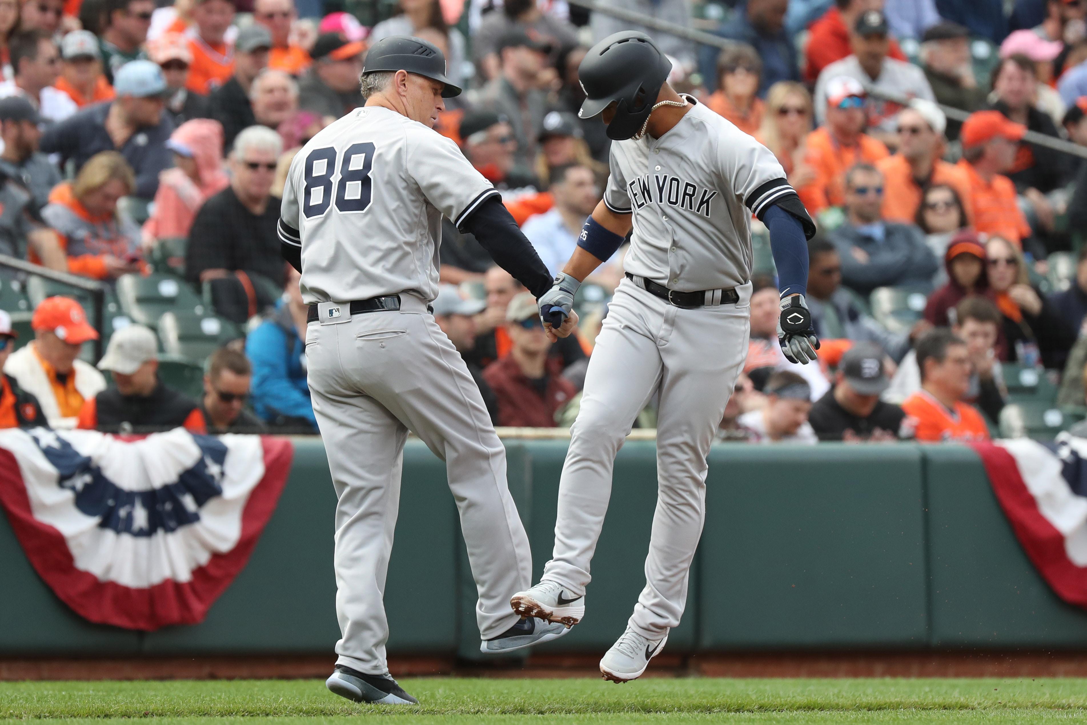 Apr 4, 2019; Baltimore, MD, USA; New York Yankees shortstop Gleyber Torres (25) is greeted by base coach Phil Nevin (88) while rounding the bases after hitting solo home run against the Baltimore Orioles at Oriole Park at Camden Yards. Mandatory Credit: Mitch Stringer-USA TODAY Sports