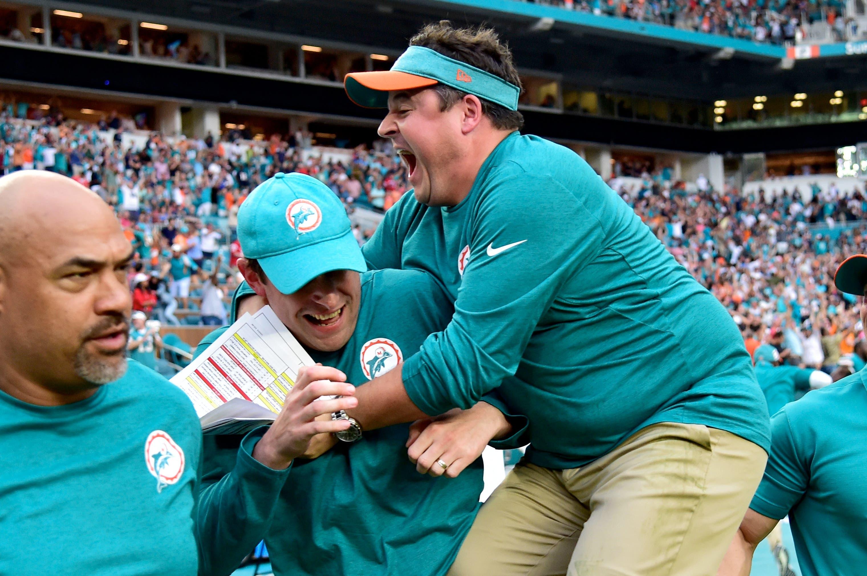 Dec 9, 2018; Miami Gardens, FL, USA; Miami Dolphins head coach Adam Gase (middle) celebrates with Dolphins offensive coordinator Dowell Loggains (right) after defeating the New England Patriots at Hard Rock Stadium. Mandatory Credit: Steve Mitchell-USA TODAY Sports / Steve Mitchell