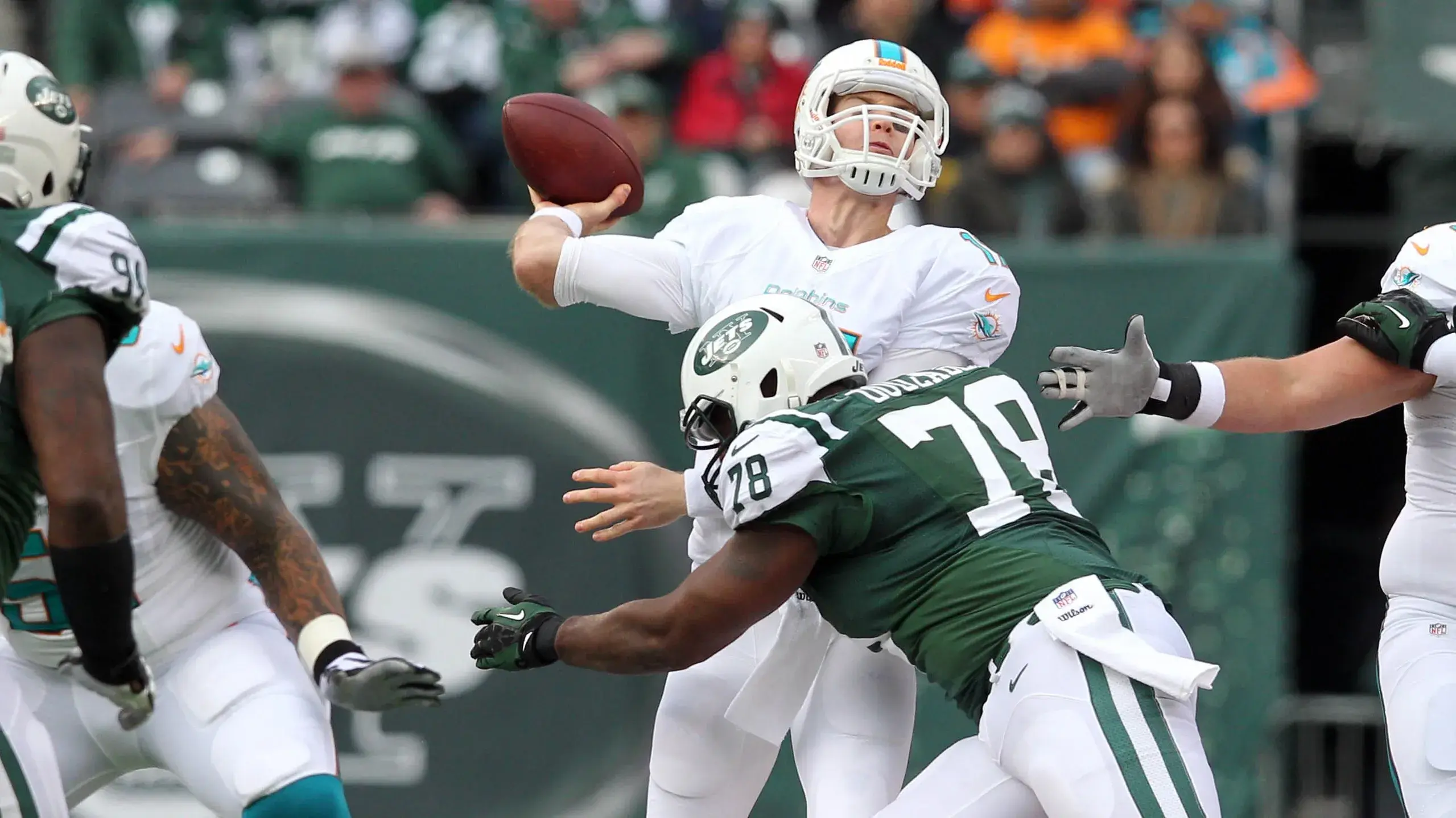 Miami Dolphins quarterback Ryan Tannehill (17) is hit as he throws by New York Jets defensive tackle Leger Douzable (78) during the first quarter of a game at MetLife Stadium. / Brad Penner-USA TODAY Sports