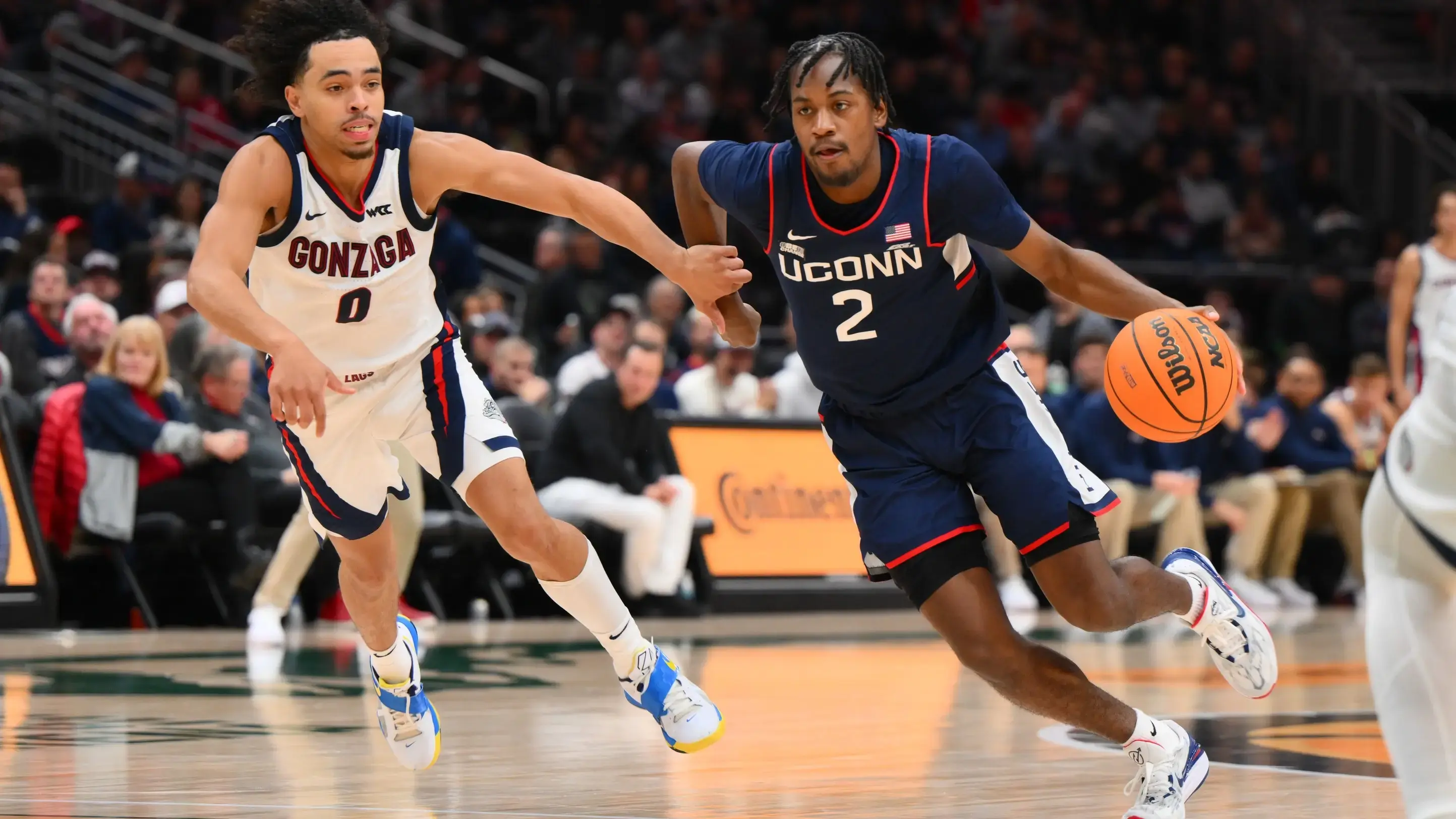 Dec 15, 2023; Seattle, Washington, USA; Connecticut Huskies guard Tristen Newton (2) dribbles the ball while guarded by Gonzaga Bulldogs guard Ryan Nembhard (0) during the second half at Climate Pledge Arena. / Steven Bisig-USA TODAY Sports