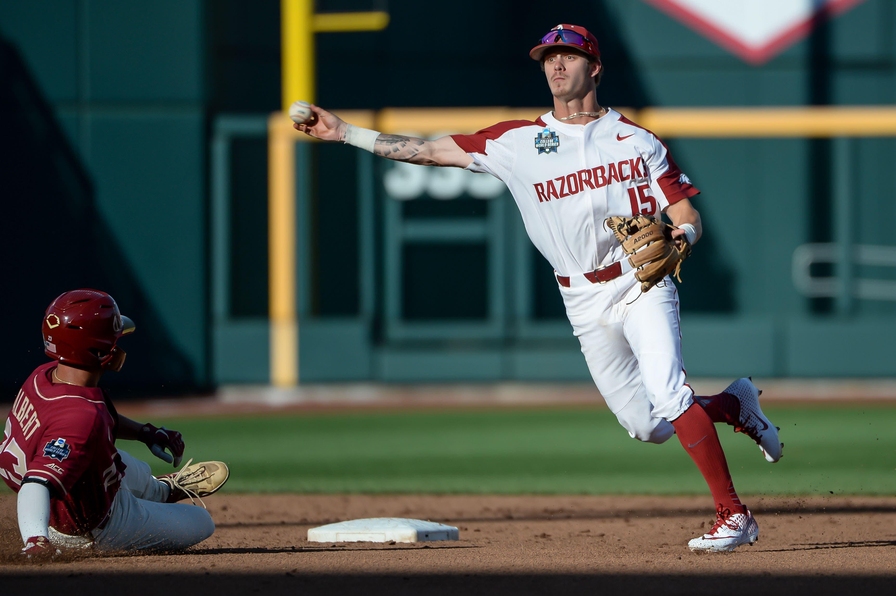 Jun 15, 2019; Omaha, NE, USA; Arkansas Razorbacks shortstop Casey Martin (15) avoids a sliding Florida State Seminoles outfielder Reese Albert (23) to complete a double play in the third inning in the 2019 College World Series at TD Ameritrade Park. Mandatory Credit: Steven Branscombe-USA TODAY Sports / Steven Branscombe