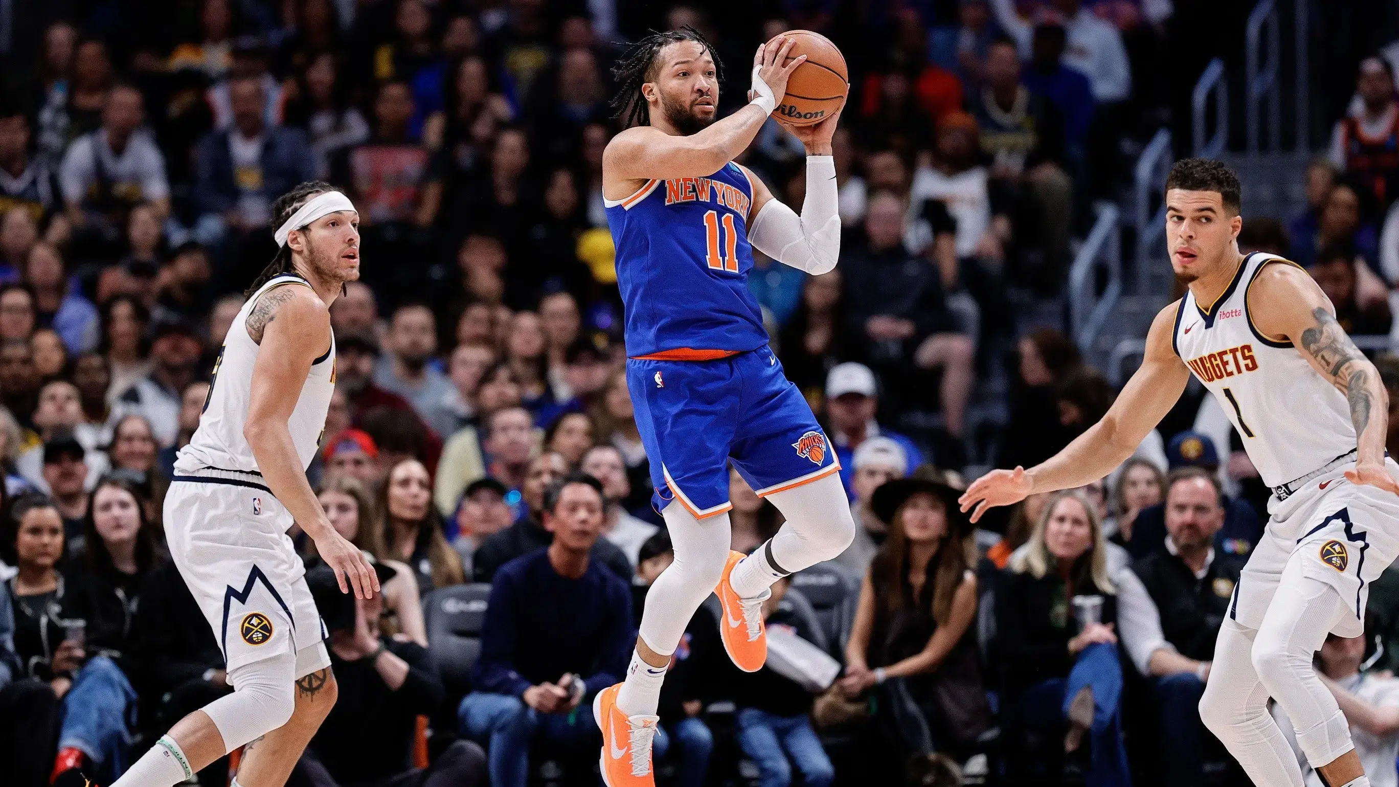 Mar 21, 2024; Denver, Colorado, USA; New York Knicks guard Jalen Brunson (11) controls the ball as Denver Nuggets forward Aaron Gordon (50) and ]forward Michael Porter Jr. (1) defend in the first quarter at Ball Arena. / Isaiah J. Downing-USA TODAY Sports