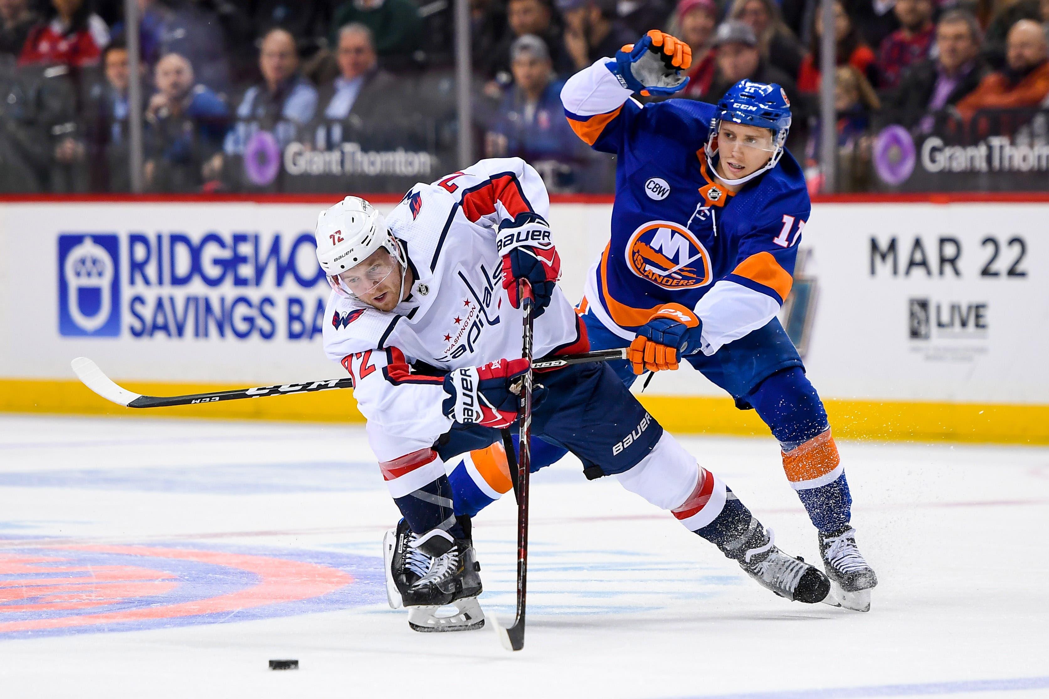 Washington Capitals center Travis Boyd attempts to bring the puck across the blue line defended by New York Islanders center Tanner Fritz during the first period at Barclays Center. / Dennis Schneidler/USA TODAY Sports