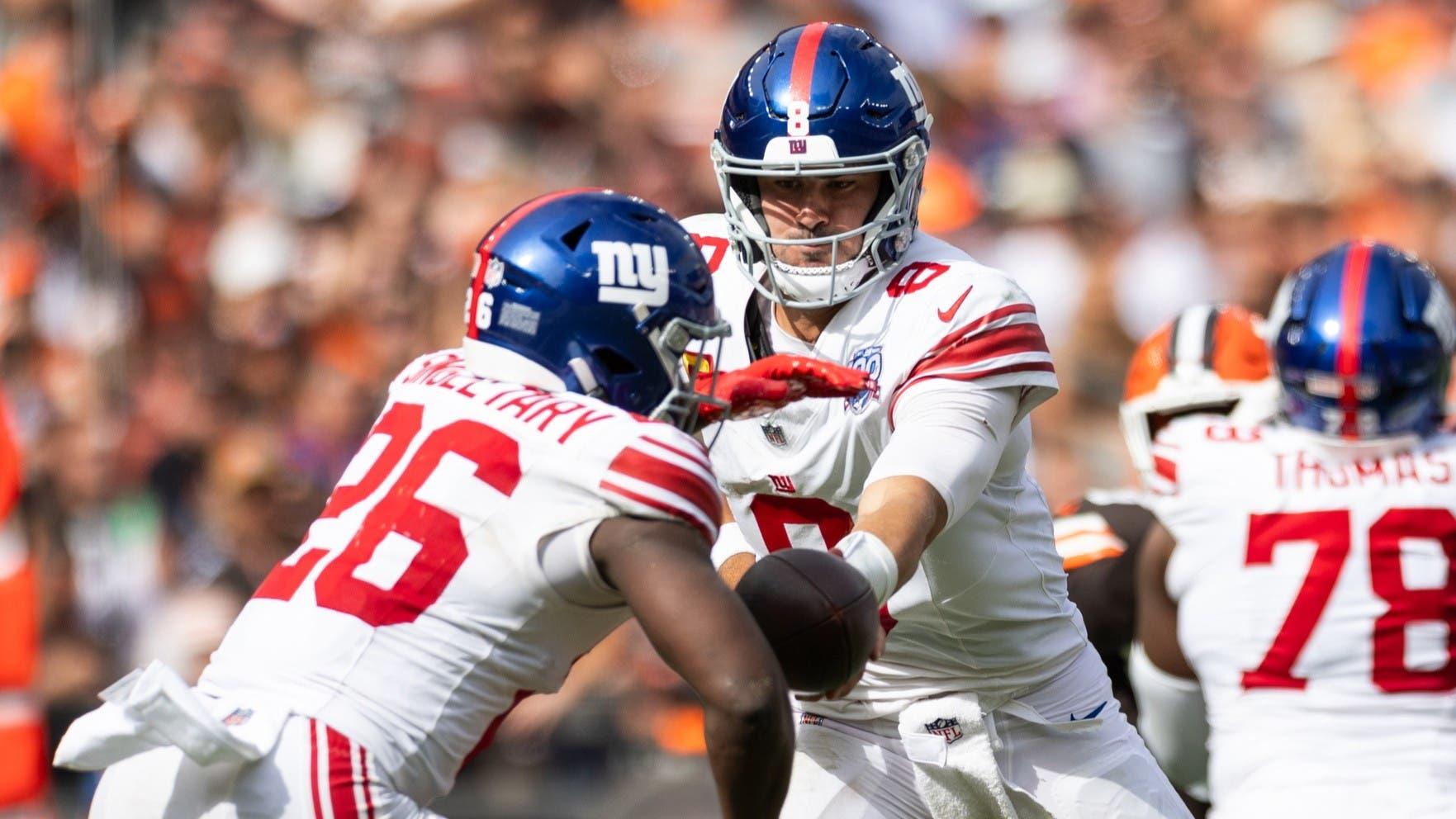 Sep 22, 2024; Cleveland, Ohio, USA; New York Giants quarterback Daniel Jones (8) hands the ball off to running back Devin Singletary (26) during the fourth quarter against the Cleveland Browns at Huntington Bank Field.