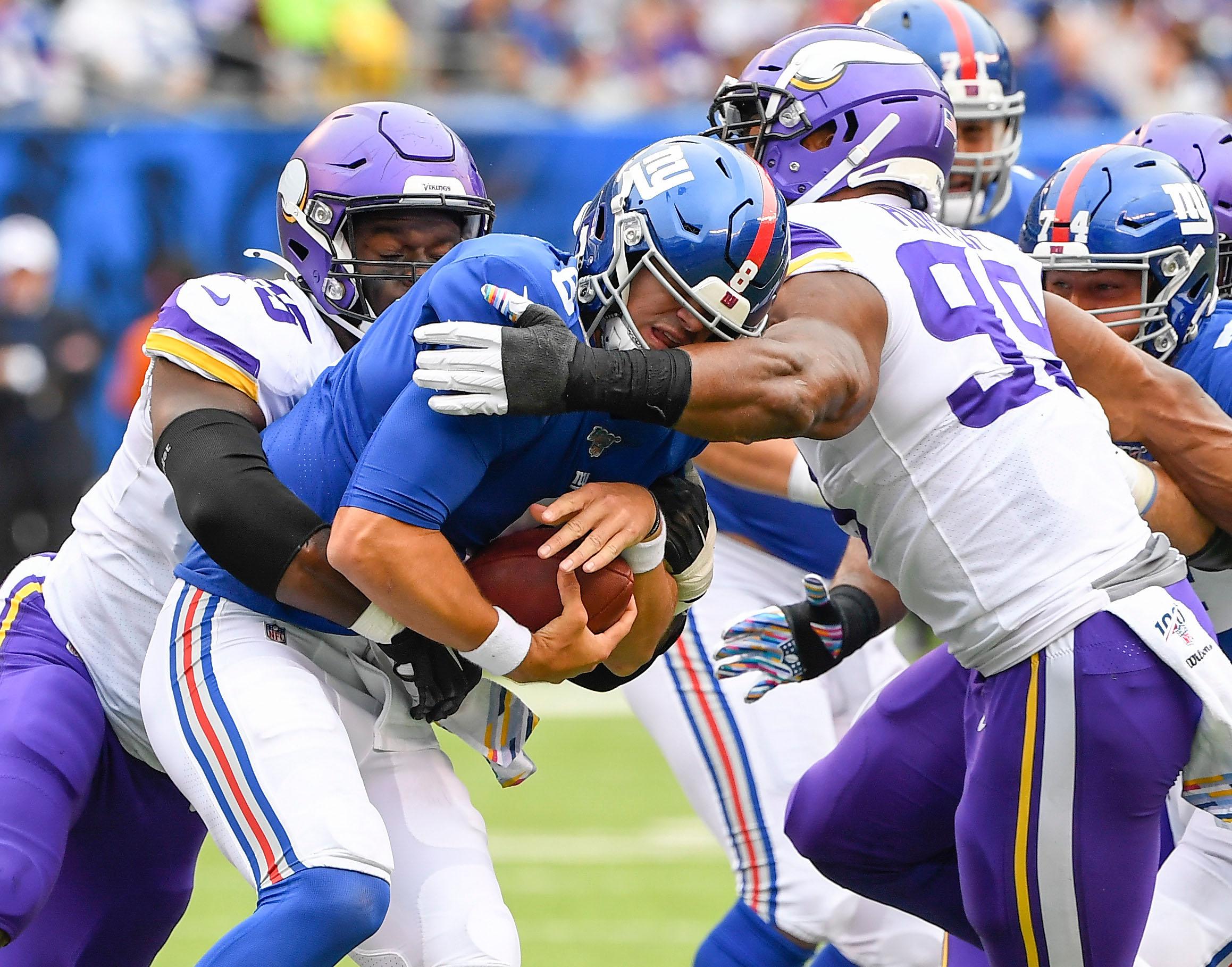 Oct 6, 2019; East Rutherford, NJ, USA; New York Giants quarterback Daniel Jones (8) is sacked by Minnesota Vikings defensive ends Ifeadi Odenigbo (95) and Danielle Hunter (99) in the 1st half at MetLife Stadium. Mandatory Credit: Robert Deutsch-USA TODAY Sports