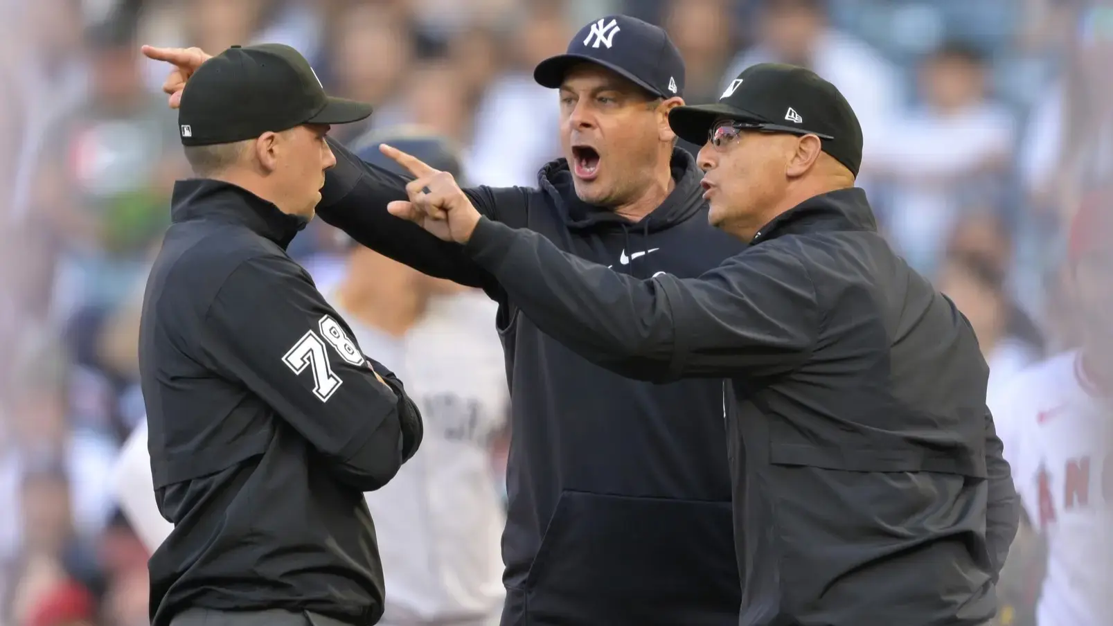 May 29, 2024; Anaheim, California, USA; Umpire Adam Hamari (78) looks on as New York Yankees manager Aaron Boone (17), who was ejected from the game, argues with umpire Vic Carapazza (19) in the first inning against the Los Angeles Angels at Angel Stadium. / Jayne Kamin-Oncea-USA TODAY Sports