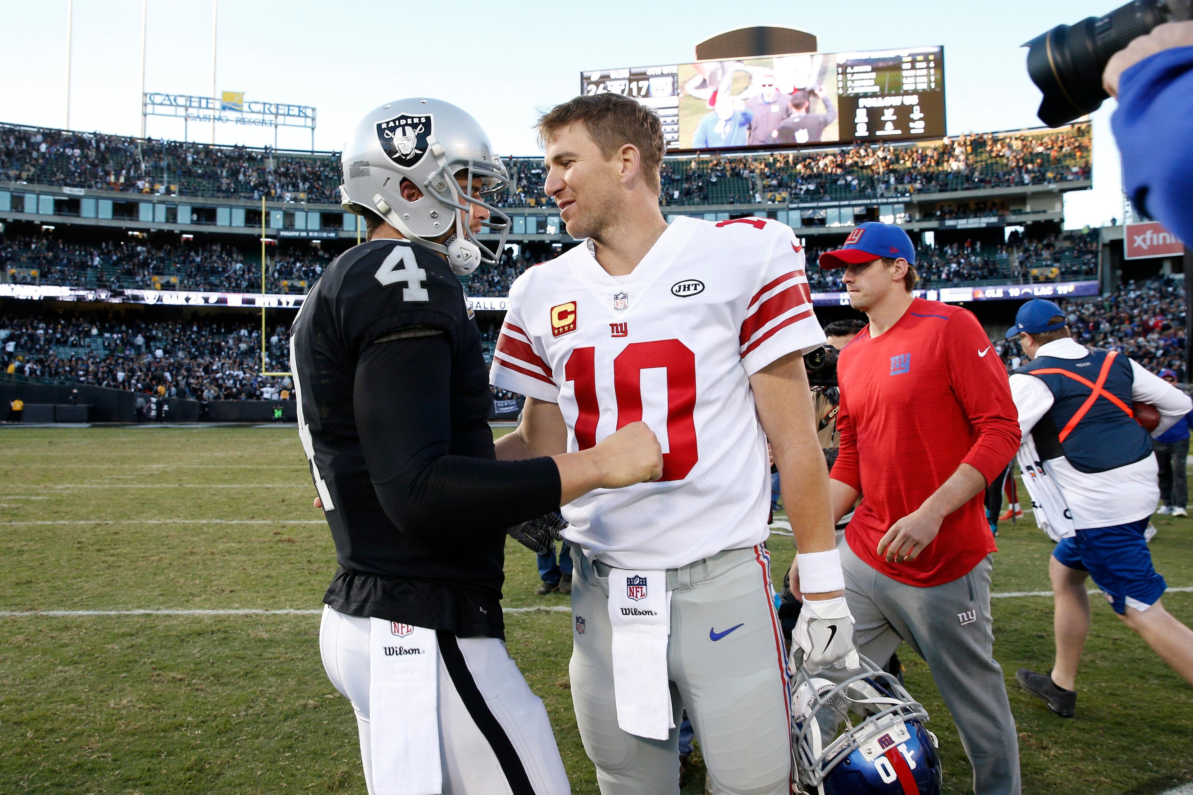 Dec 3, 2017; Oakland, CA, USA; New York Giants quarterback Eli Manning (10) is greeted by Oakland Raiders quarterback Derek Carr (4) after the game at Oakland Coliseum. Mandatory Credit: Cary Edmondson-USA TODAY Sports