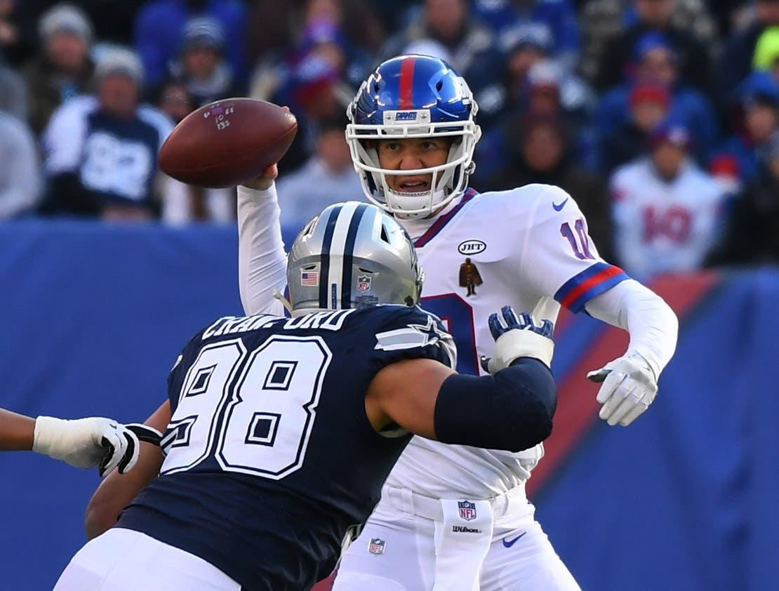 New York Giants quarterback Eli Manning throws a pass against Dallas Cowboys defensive end Tyrone Crawford in the first half during a NFL football game at MetLife Stadium. / Robert Deutsch/USA TODAY Sports