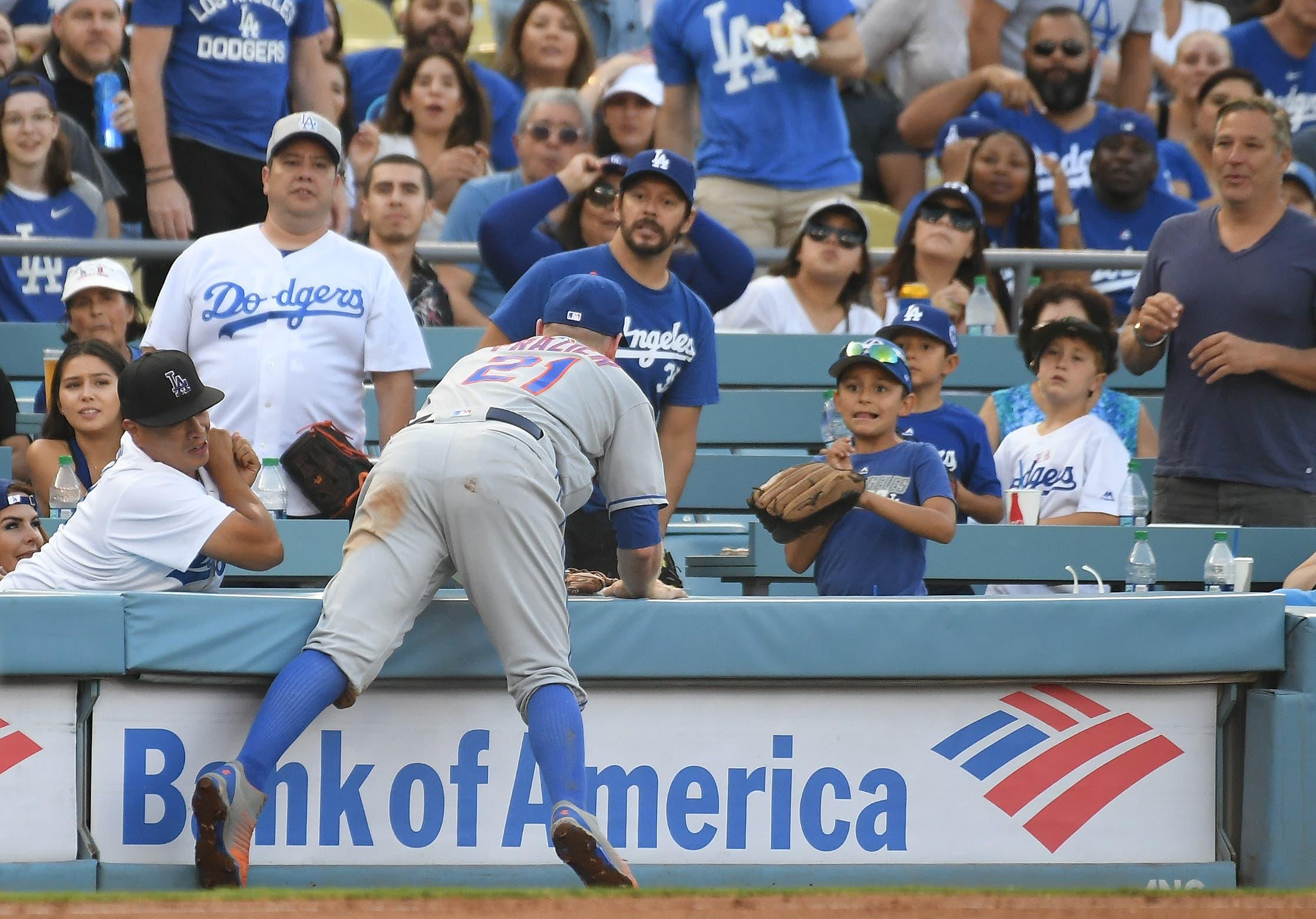 Sep 3, 2018; Los Angeles, CA, USA; New York Mets third baseman Todd Frazier (21) goes over the wall to catch a ball hit by Los Angeles Dodgers center fielder Alex Verdugo (61) in the second inning at Dodger Stadium. Mandatory Credit: Richard Mackson-USA TODAY Sports / Richard Mackson