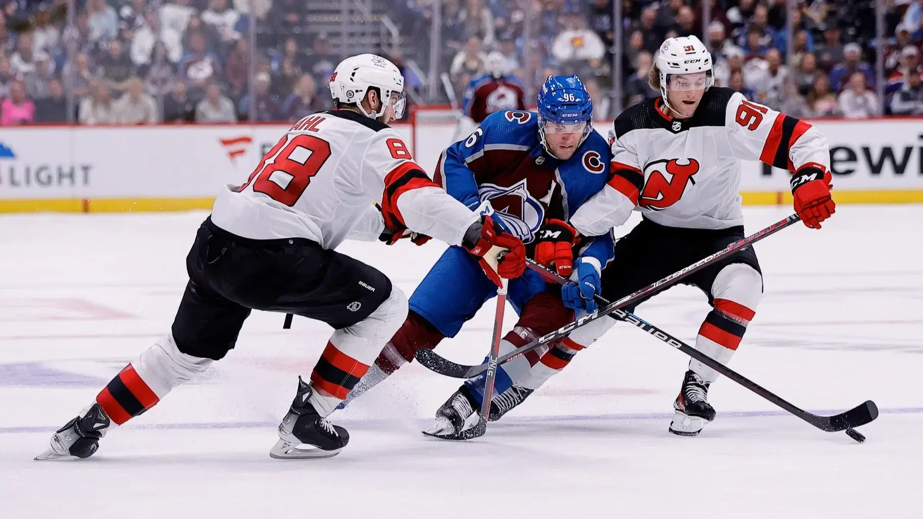 Nov 7, 2023; Denver, Colorado, USA; Colorado Avalanche right wing Mikko Rantanen (96) is pushed off the puck against New Jersey Devils defenseman Kevin Bahl (88) and center Dawson Mercer (91) in the second period at Ball Arena. / Isaiah J. Downing-USA TODAY Sports