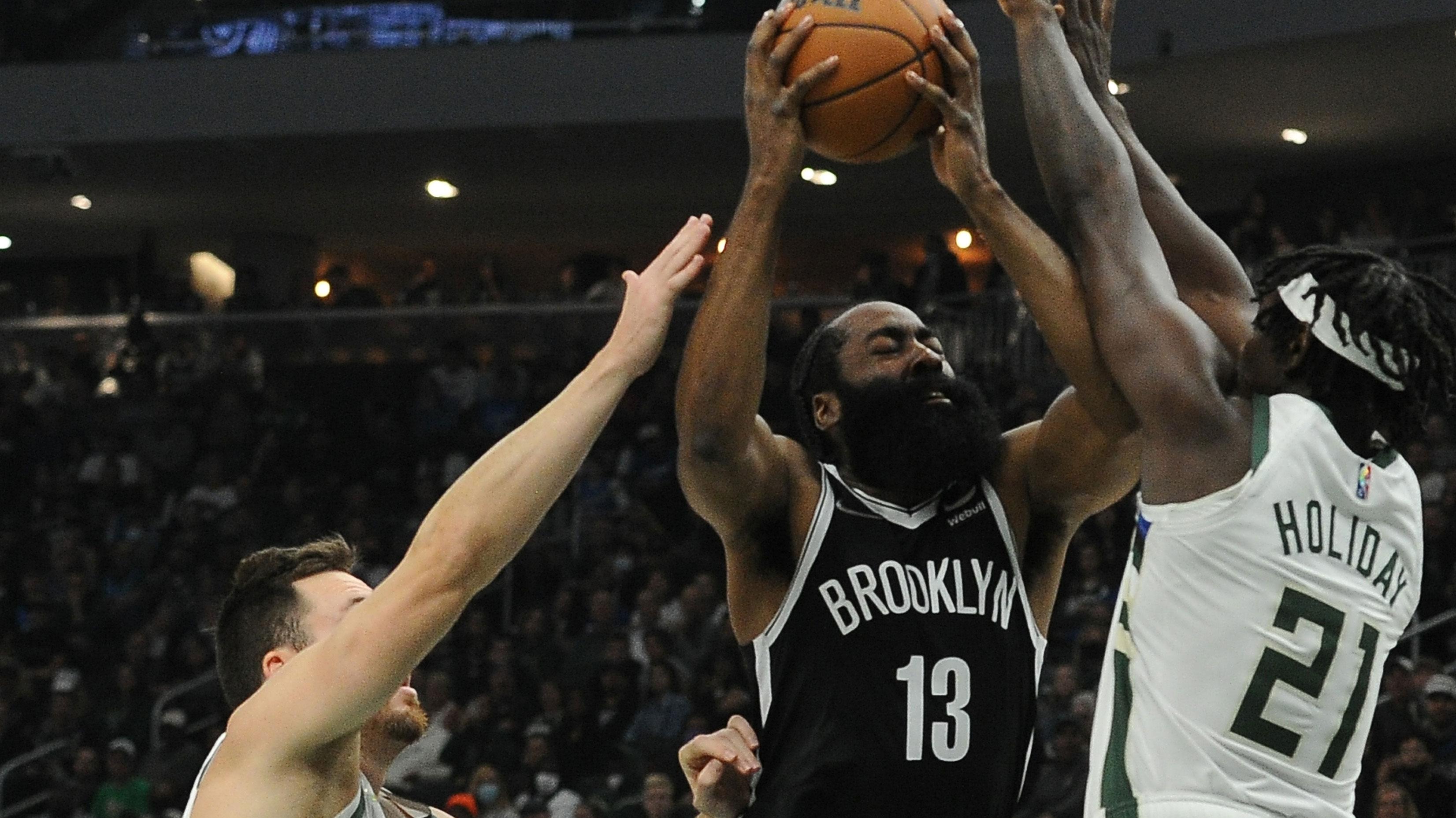 Oct 19, 2021; Milwaukee, Wisconsin, USA; Brooklyn Nets guard James Harden (13) drives to the basket against Milwaukee Bucks guard Pat Connaughton (24) and guard Jrue Holiday (21) in the first half at Fiserv Forum. / Michael McLoone-USA TODAY Sports