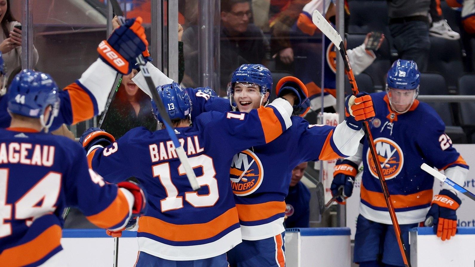 New York Islanders defenseman Noah Dobson (8) celebrates with teammates after scoring the game winning overtime goal against the Calgary Flames. / Brad Penner-USA TODAY Sports
