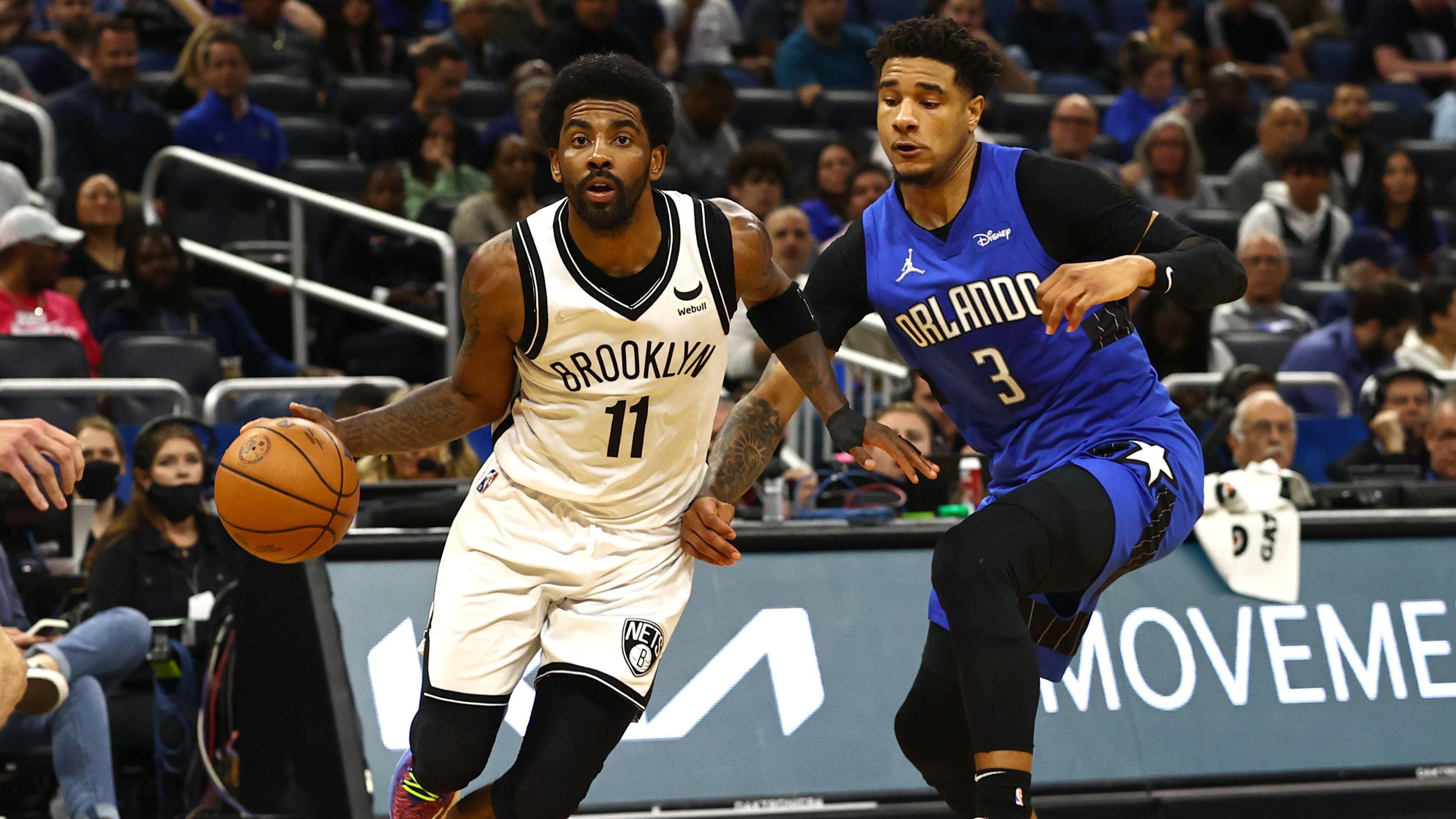 Mar 15, 2022; Orlando, Florida, USA; Brooklyn Nets guard Kyrie Irving (11) drives to the basket as Orlando Magic forward Chuma Okeke (3) defends during the second quarter at Amway Center. / Kim Klement-USA TODAY Sports