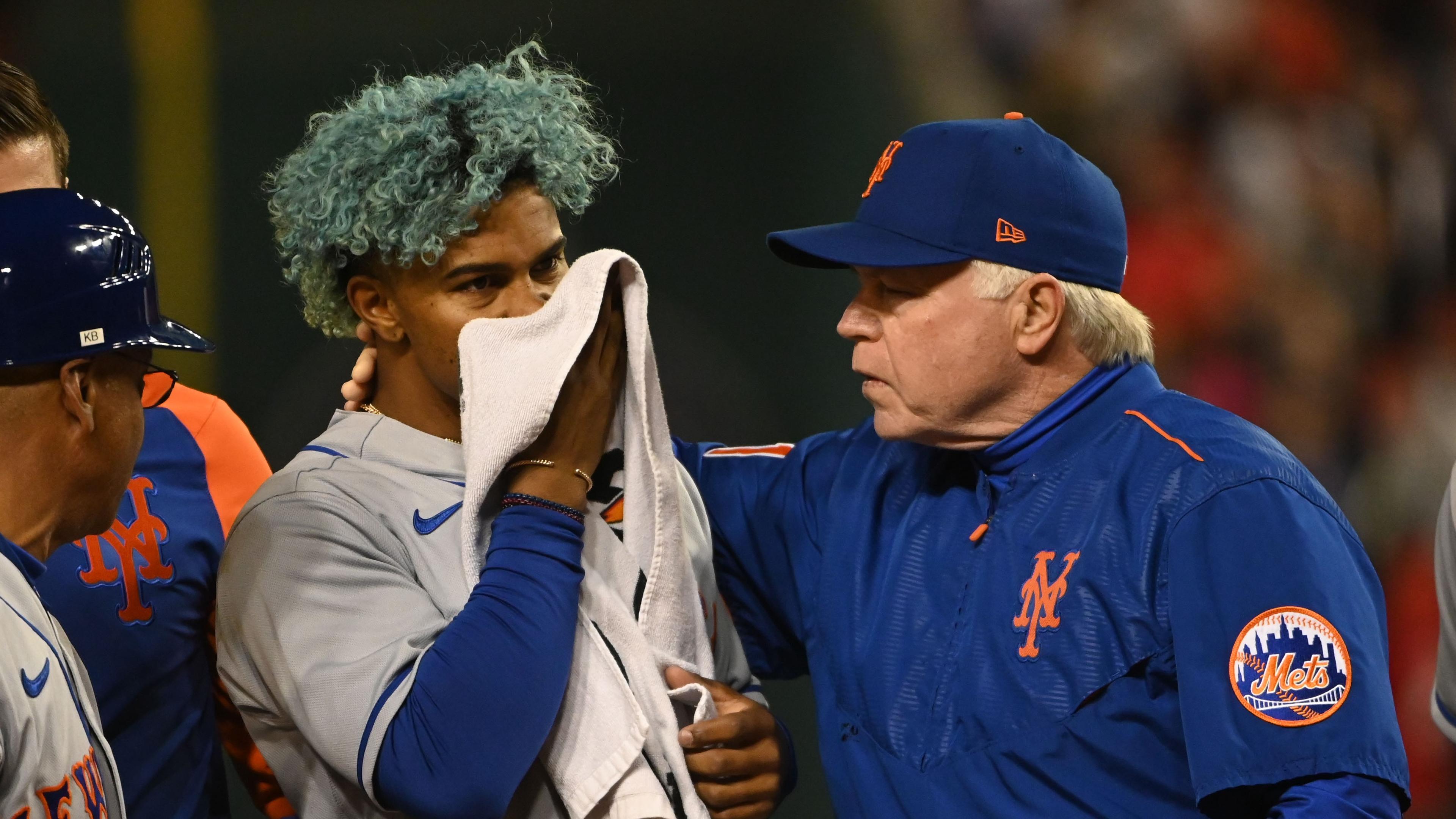 Apr 8, 2022; Washington, District of Columbia, USA; New York Mets shortstop Francisco Lindor (12) covers his face after being hit by pitch while manager Buck Showalter (11) walks with him during the fifth inning against the Washington Nationals at Nationals Park. Mandatory Credit: Tommy Gilligan-USA TODAY Sports / Tommy Gilligan-USA TODAY Sports