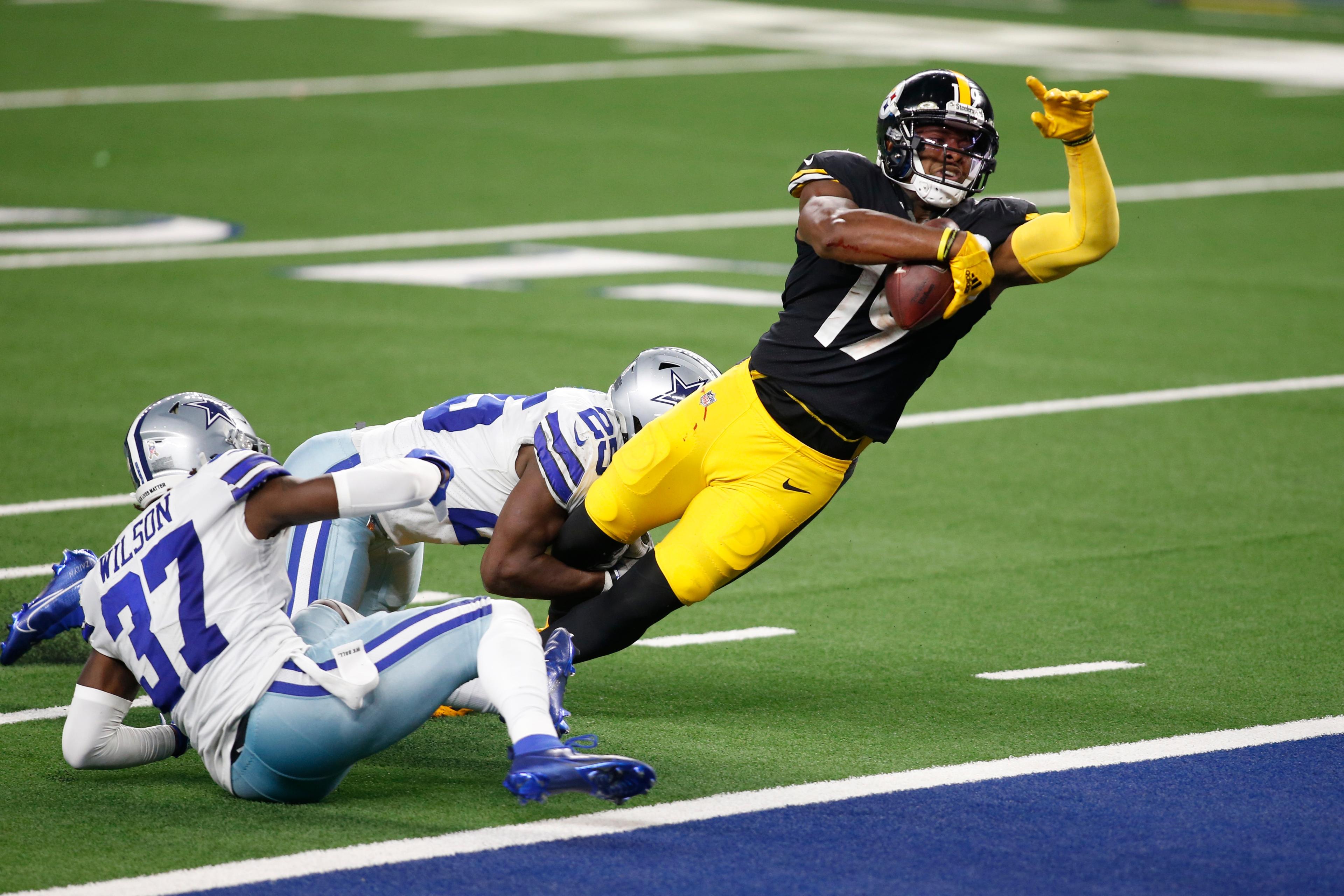 Nov 8, 2020; Arlington, Texas, USA; Pittsburgh Steelers wide receiver JuJu Smith-Schuster (19) catches a pass and runs for a touchdown against Dallas Cowboys free safety Xavier Woods (25) and safety Donovan Wilson (37) in the fourth quarter at AT&T Stadium. / © Tim Heitman-USA TODAY Sports