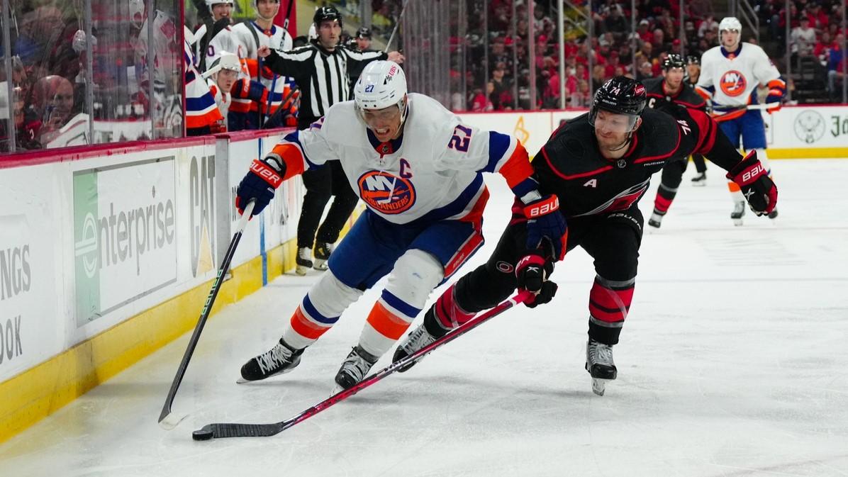 Apr 20, 2024; Raleigh, North Carolina, USA; New York Islanders Anders Lee (27) skates with the puck outside of Carolina Hurricanes defenseman Jaccob Slavin (74) during the second period in game one of the first round of the 2024 Stanley Cup Playoffs at PNC Arena. / James Guillory-USA TODAY Sports