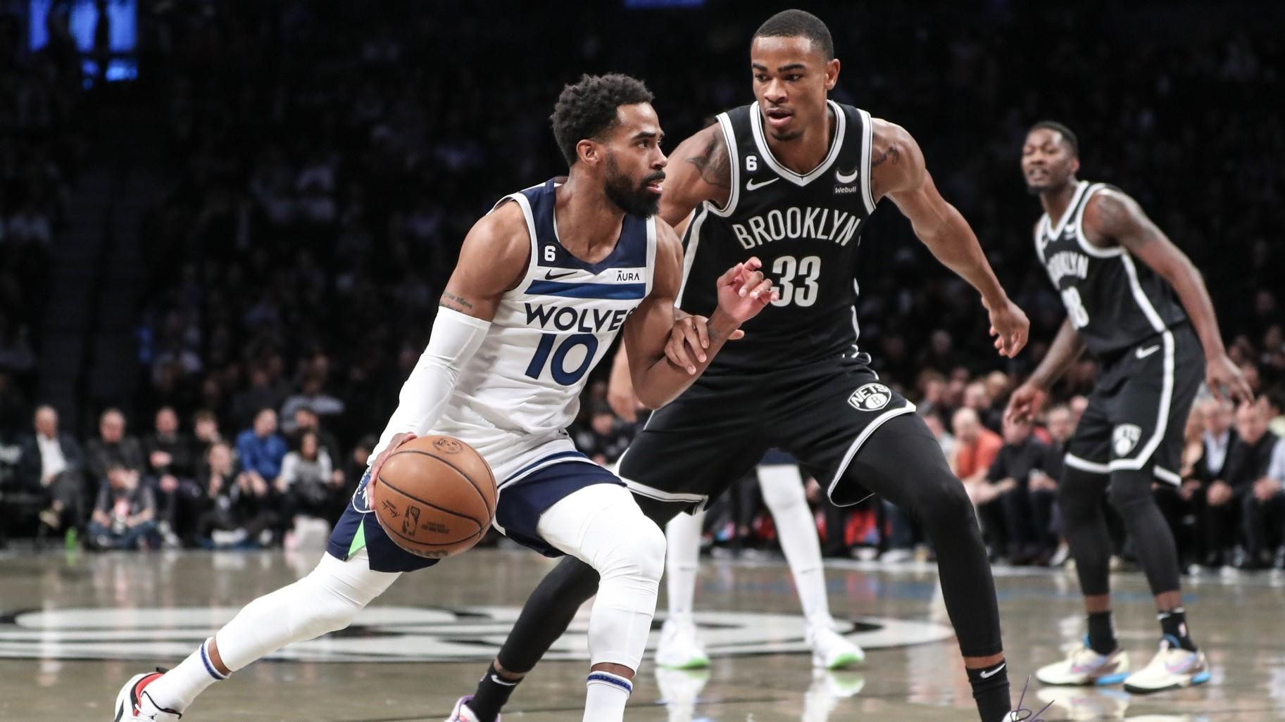 Apr 4, 2023; Brooklyn, New York, USA; Minnesota Timberwolves guard Mike Conley (10) looks to drive past Brooklyn Nets center Nic Claxton (33) in the first quarter at Barclays Center. / Wendell Cruz-USA TODAY Sports