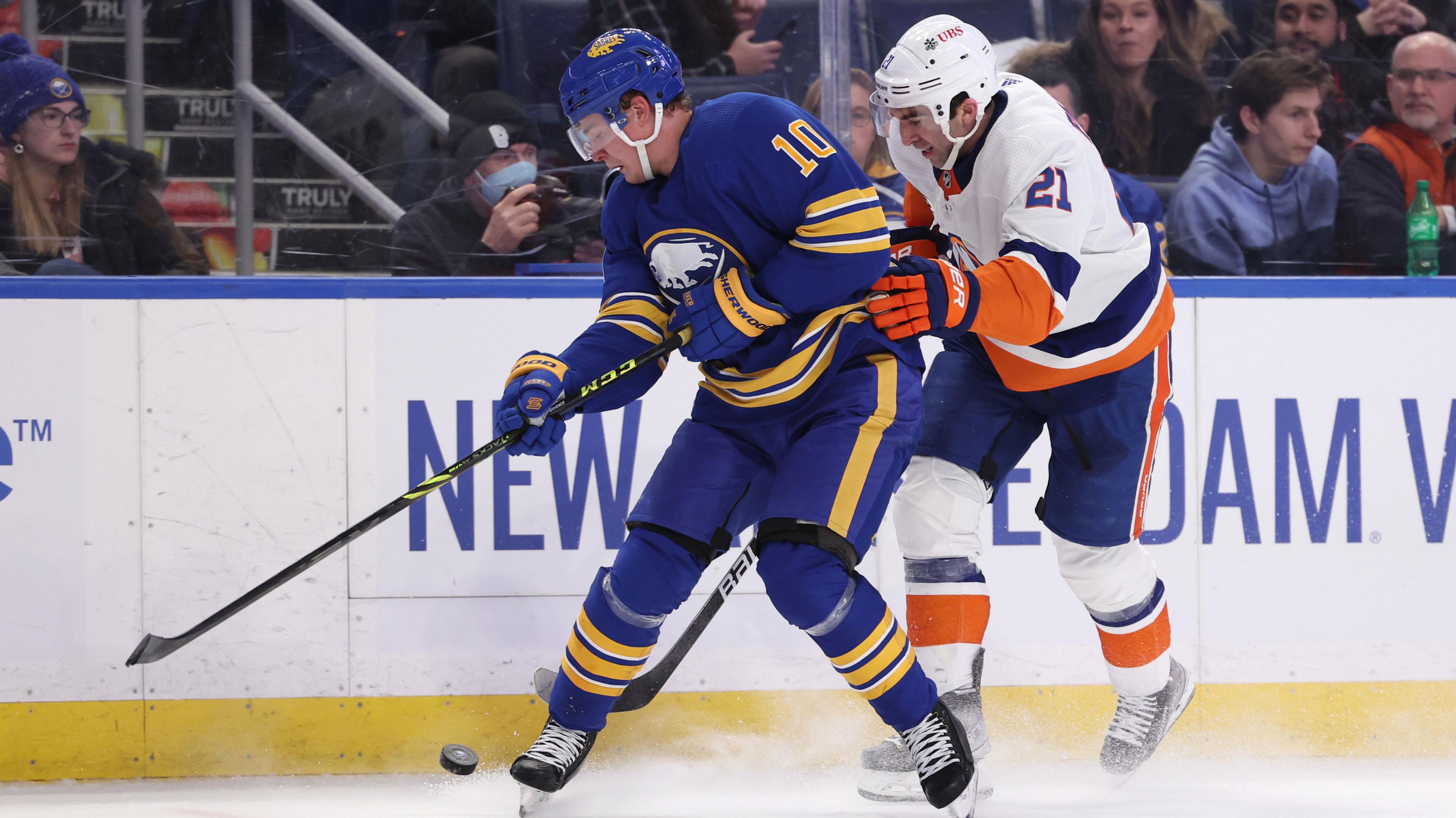 Feb 15, 2022; Buffalo, New York, USA; Buffalo Sabres defenseman Henri Jokiharju (10) and New York Islanders right wing Kyle Palmieri (21) go after a loose puck along the boards during the first period at KeyBank Center. / Timothy T. Ludwig-USA TODAY Sports