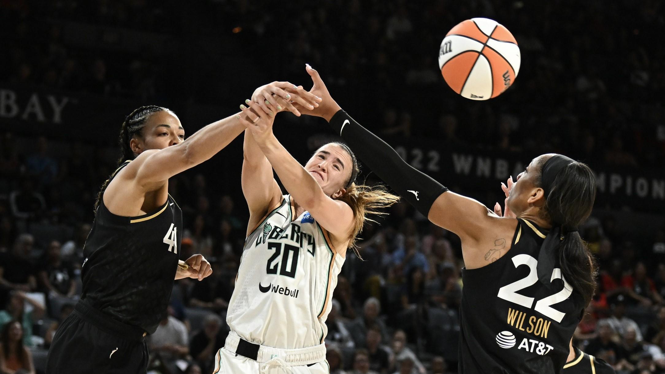 Aug 15, 2023; Las Vegas, Nevada, USA; Las Vegas Aces center Kiah Stokes (41) and forward A'ja Wilson (22) battle for a rebound with New York Liberty guard Sabrina Ionescu (20) during the second quarter at Michelob Ultra Arena. / Candice Ward-USA TODAY Sports
