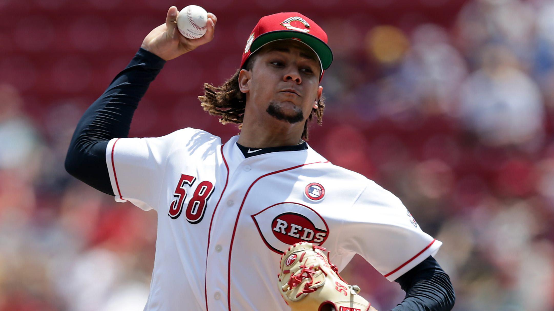 Luis Castillo fires pitch to plate in white Reds jersey / Kareem Elgazzar/USA TODAY