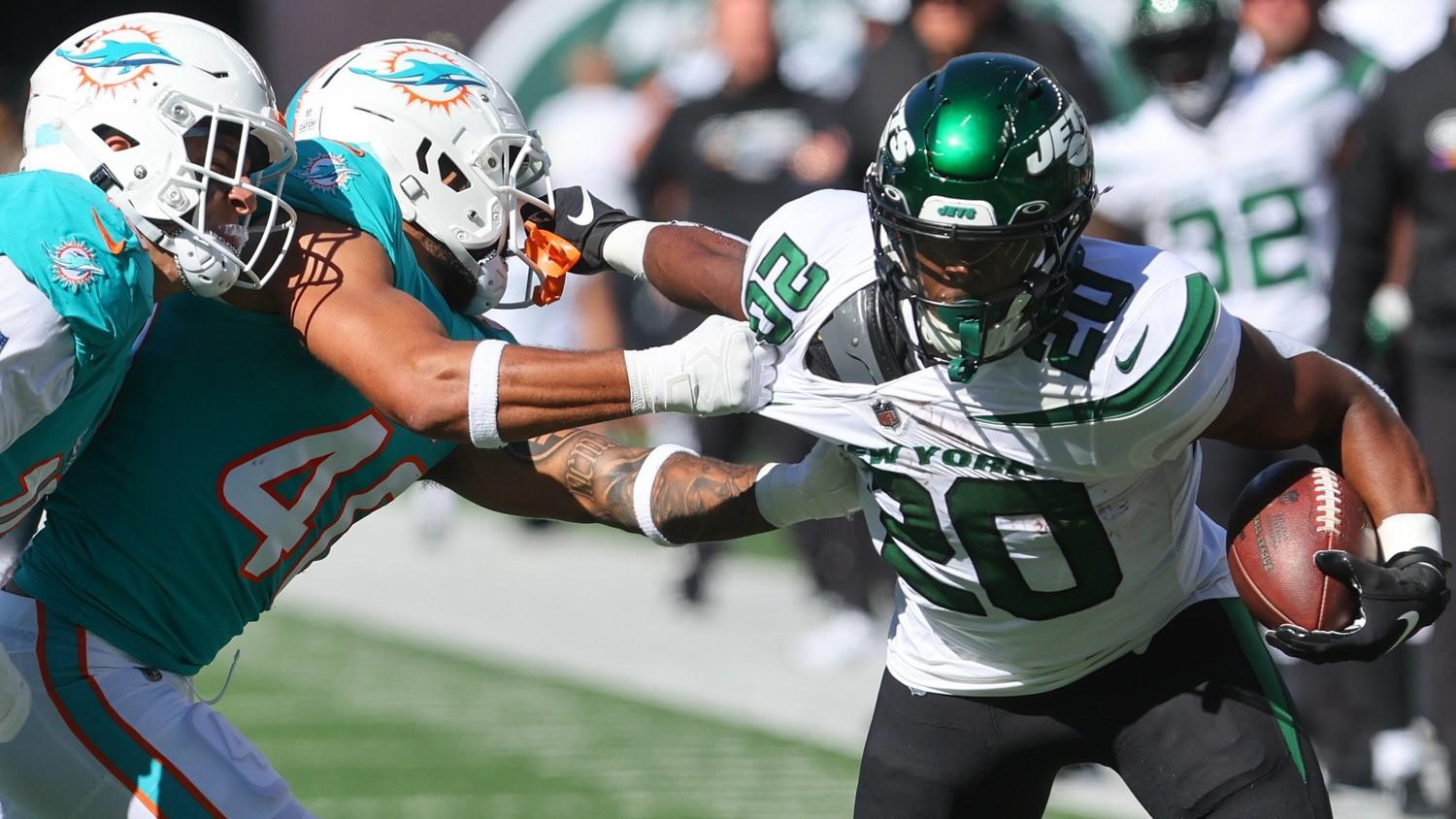 Oct 9, 2022; East Rutherford, New Jersey, USA; New York Jets running back Breece Hall (20) runs with the ball while Miami Dolphins cornerback Nik Needham (40) attempts to tackle him during the first half at MetLife Stadium. / Ed Mulholland-USA TODAY Sports