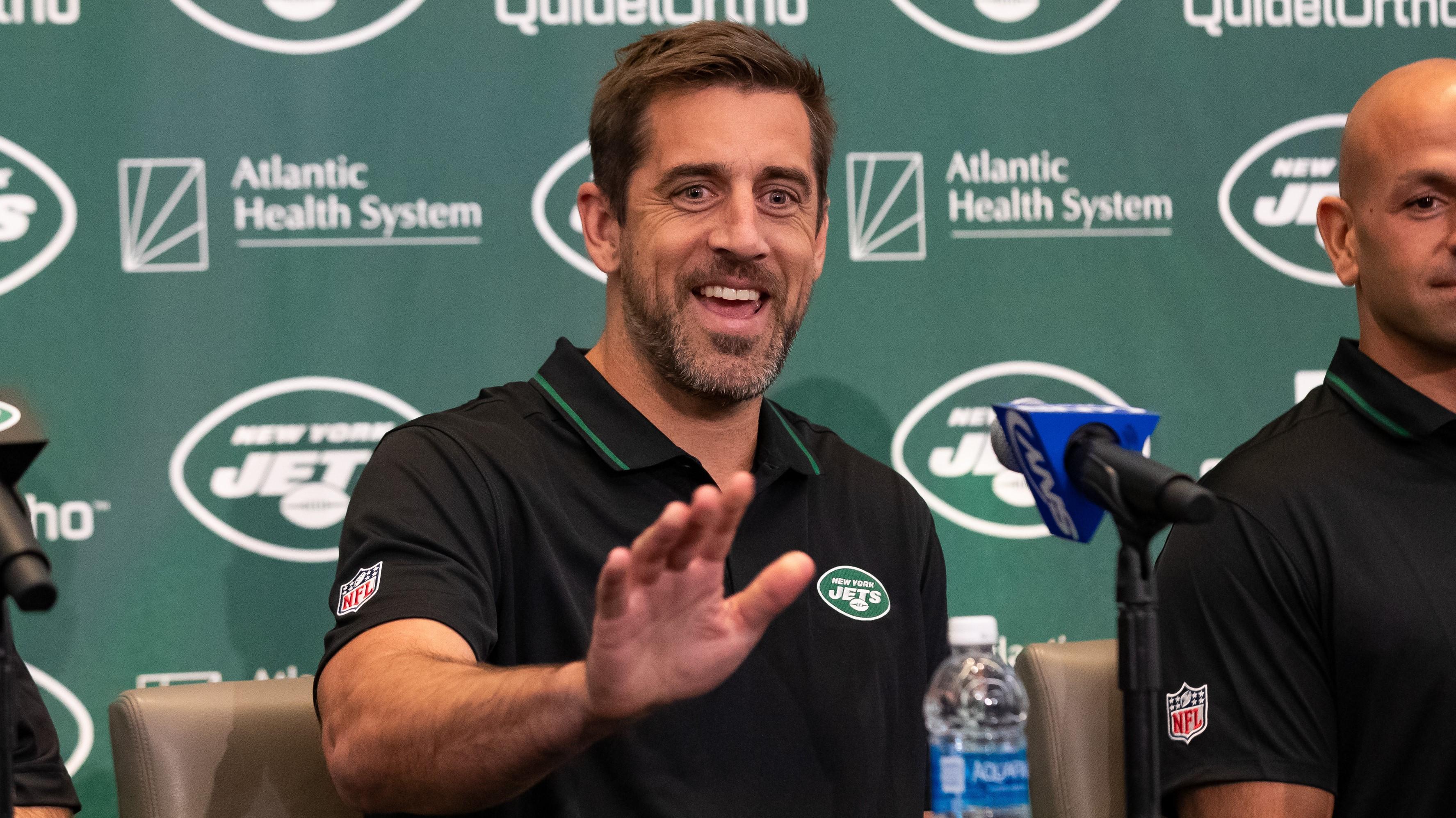 Aaron Rodgers waves to someone during his introductory news conference with the Jets. / Tom Horak-USA TODAY Sports