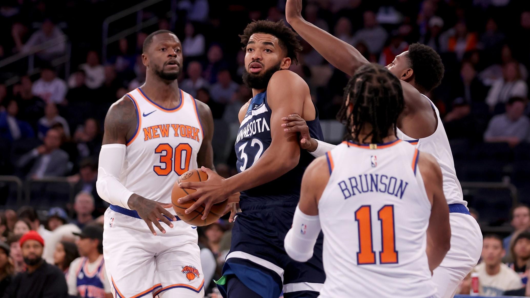 Oct 14, 2023; New York, New York, USA; Minnesota Timberwolves center Karl-Anthony Towns (32) controls the ball against New York Knicks forward Julius Randle (30) and guards RJ Barrett (9) and Jalen Brunson (11) during the first quarter at Madison Square Garden. / Brad Penner-USA TODAY Sports