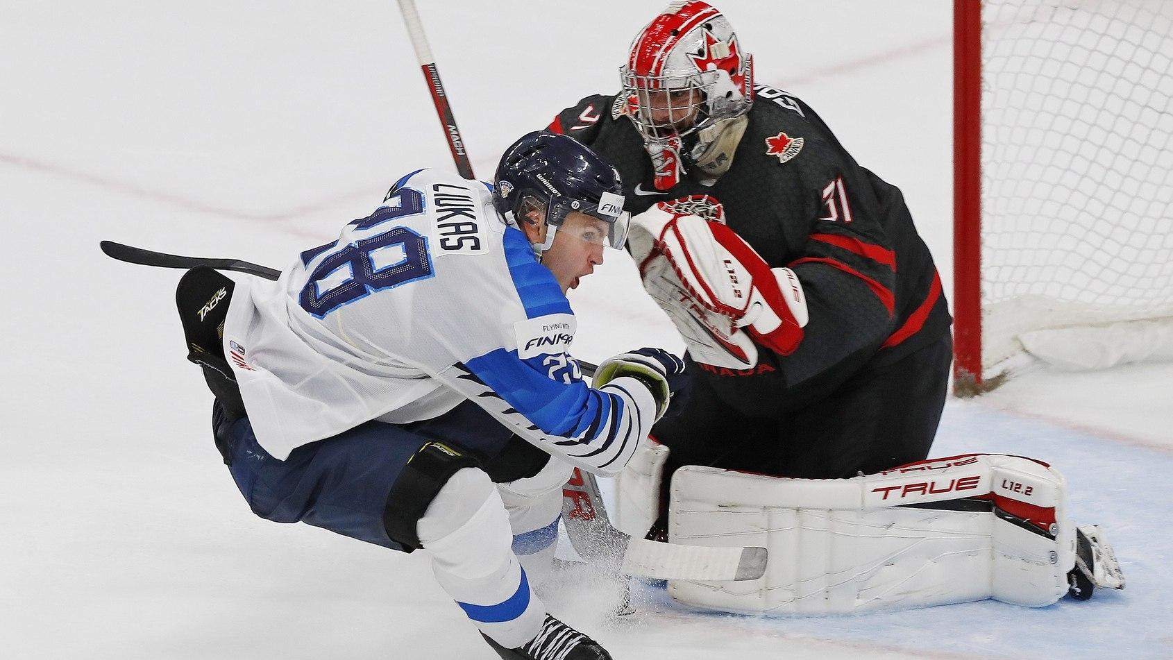 Team Canada goaltender Dylan Garand (31) makes a save on Team Finland forward Eetu Liukas (28) during the third period / Perry Nelson-USA TODAY Sports