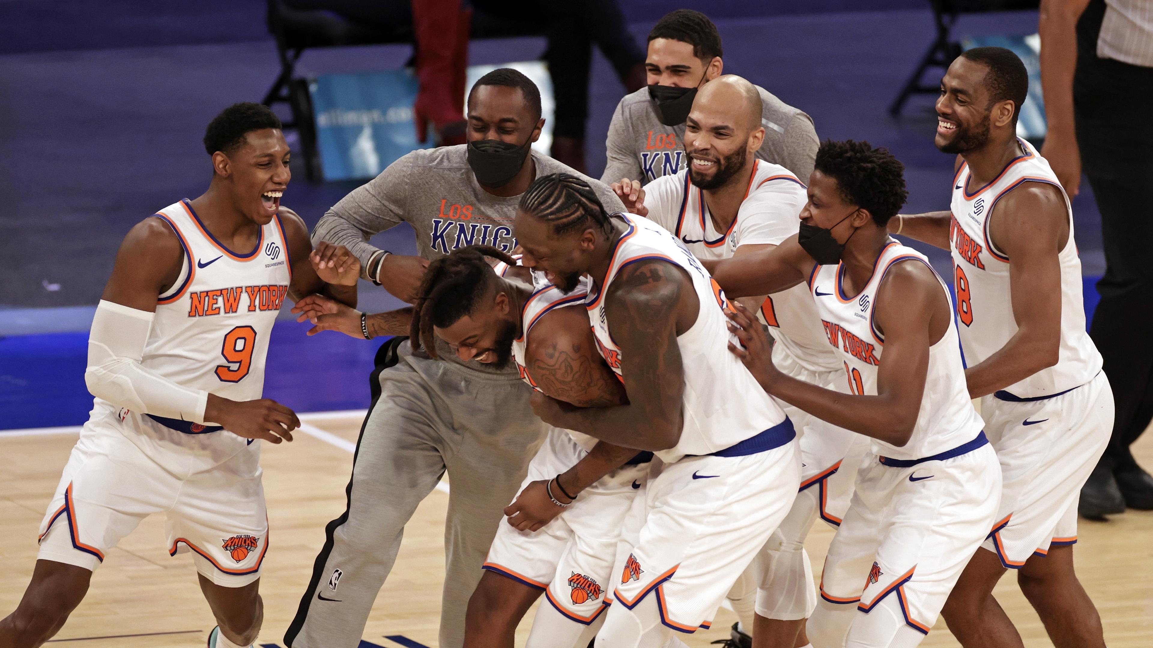Mar 18, 2021; New York, New York, USA; New York Knicks forward Reggie Bullock is mobbed by teammates after taking the ball away from the Orlando Magic in the final seconds of the second half of an NBA basketball game Thursday, March 18, 2021, in New York. The Knicks won 94-93. / © Pool Photo-USA TODAY Sports
