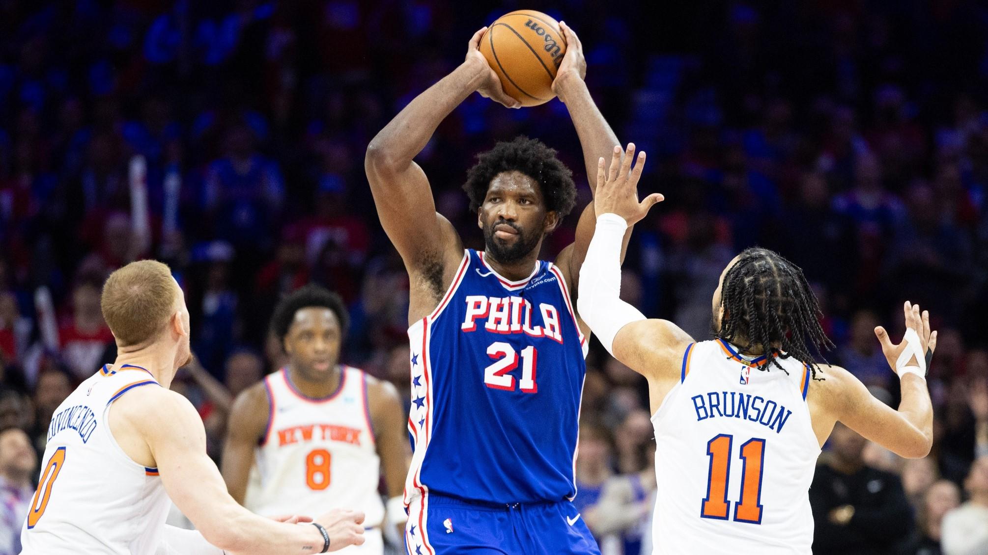 Apr 25, 2024; Philadelphia, Pennsylvania, USA; Philadelphia 76ers center Joel Embiid (21) controls the ball in front of New York Knicks guard Jalen Brunson (11) and guard Donte DiVincenzo (0) during the second half of game three of the first round for the 2024 NBA playoffs at Wells Fargo Center. / Bill Streicher-USA TODAY Sports
