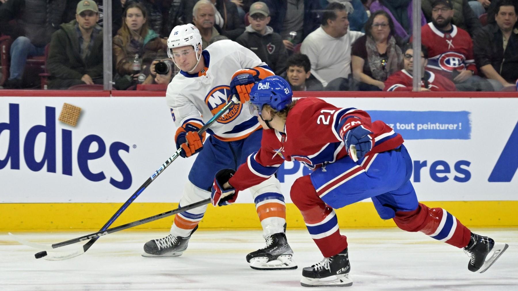 Dec 16, 2023; Montreal, Quebec, CAN; New York Islanders forward Julien Gauthier (16) plays the puck and Montreal Canadiens defenseman Kaiden Guhle (21) defends during the first period at the Bell Centre. / Eric Bolte-USA TODAY Sports
