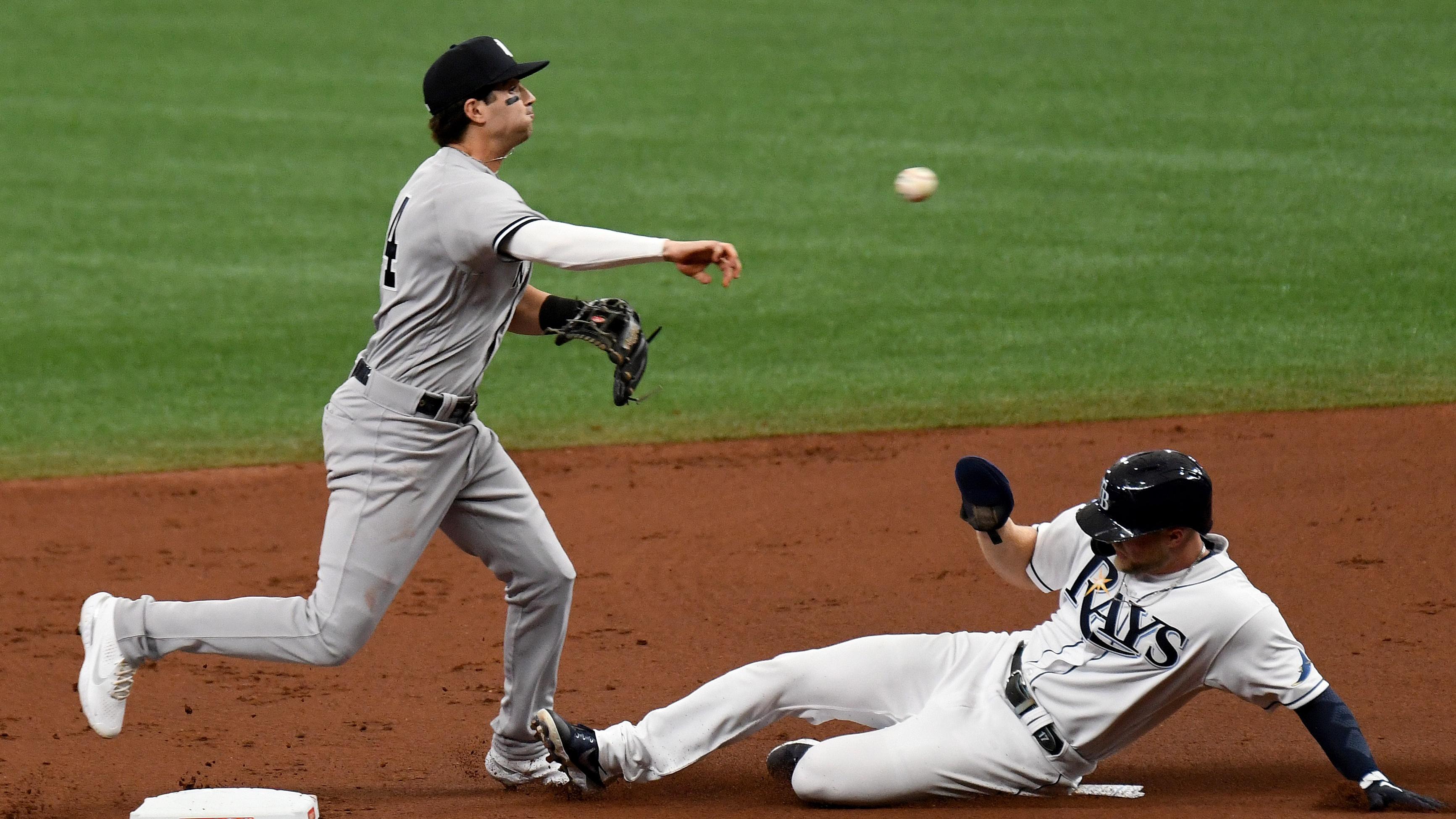 Apr 9, 2021; St. Petersburg, Florida, USA; New York Yankees infielder Tyler Wade (14) throws to first base as Tampa Bay Rays outfielder Austin Meadows (17) slides in the first inning at Tropicana Field. Mandatory Credit: Jonathan Dyer-USA TODAY Sports / © Jonathan Dyer-USA TODAY Sports