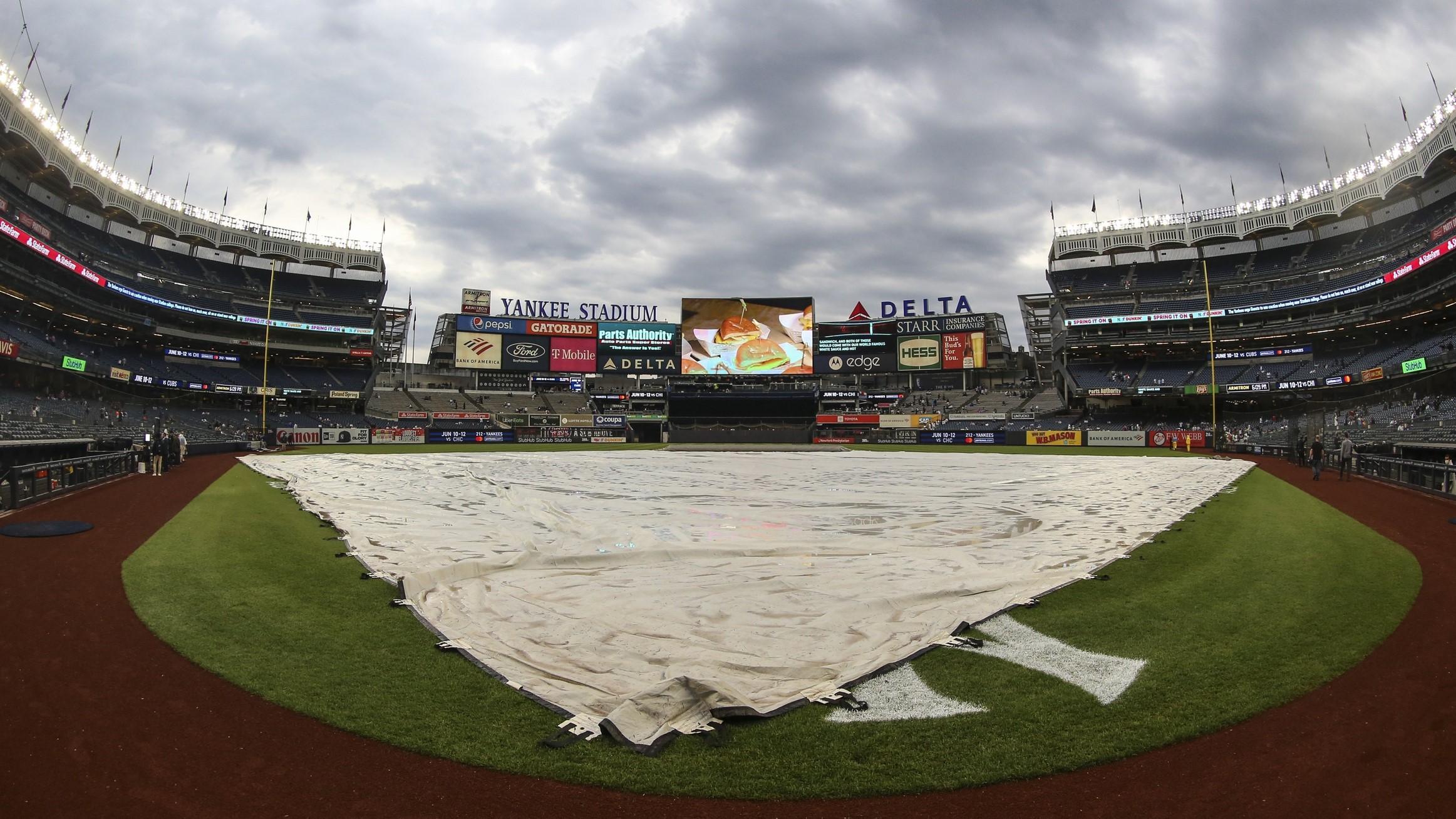 Apr 14, 2022; Bronx, New York, USA; The tarp is placed over the field prior to the game between the Toronto Blue Jays and the New York Yankees at Yankee Stadium. / Wendell Cruz-USA TODAY Sports