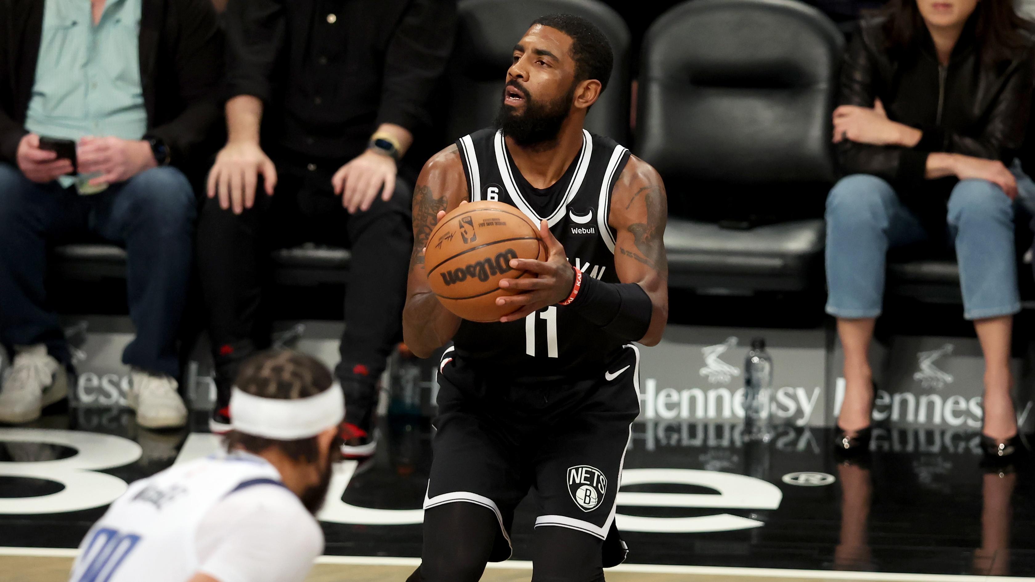 Brooklyn Nets guard Kyrie Irving (11) shoots a three point shot against Dallas Mavericks center JaVale McGee (00) during the first quarter at Barclays Center. / Brad Penner - USA TODAY Sports