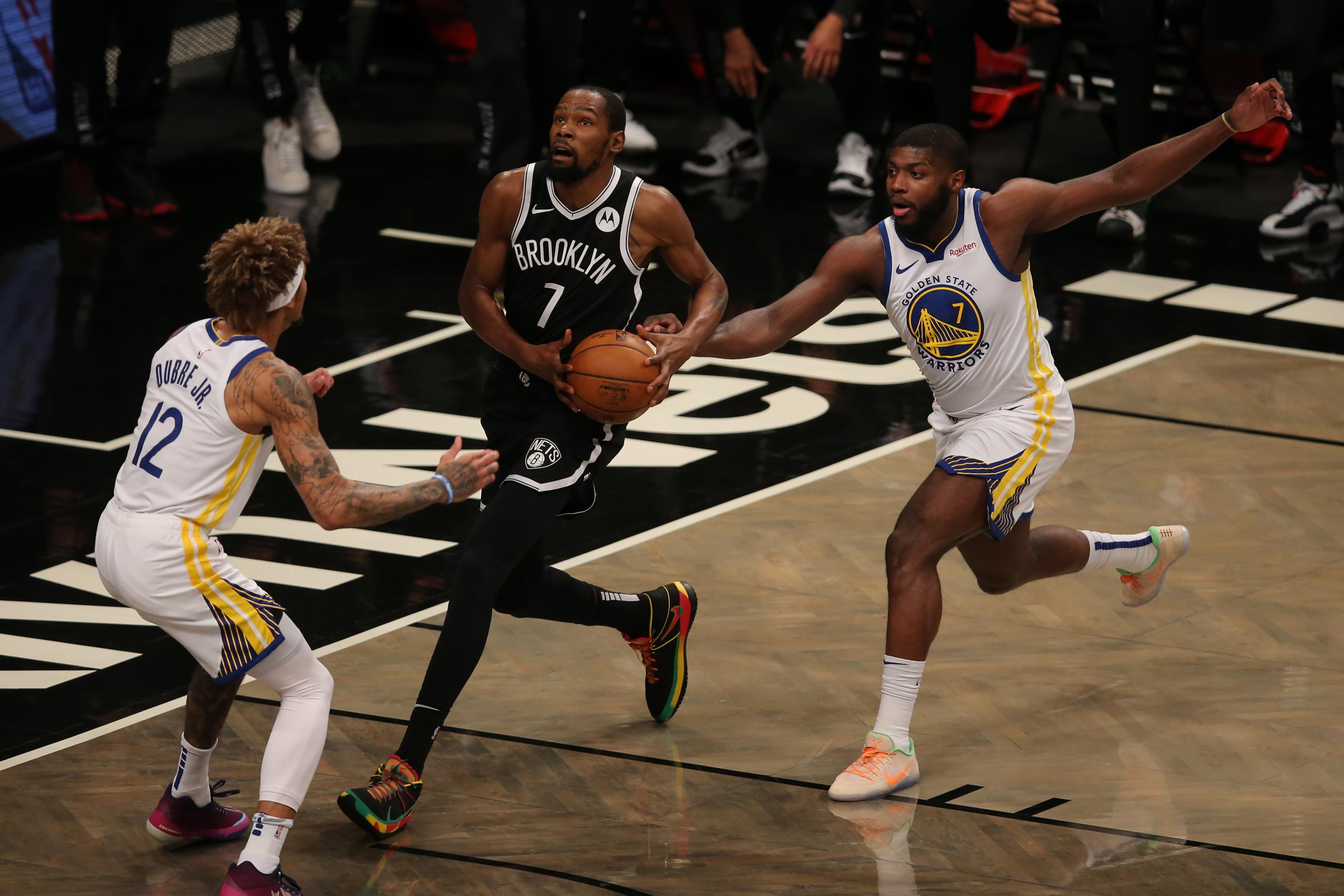 Dec 22, 2020; Brooklyn, New York, USA; Brooklyn Nets small forward Kevin Durant (7) drives against Golden State Warriors small forward Kelly Oubre Jr. (12) and power forward Eric Paschall (7) during the first quarter at Barclays Center. / Brad Penner-USA TODAY Sports