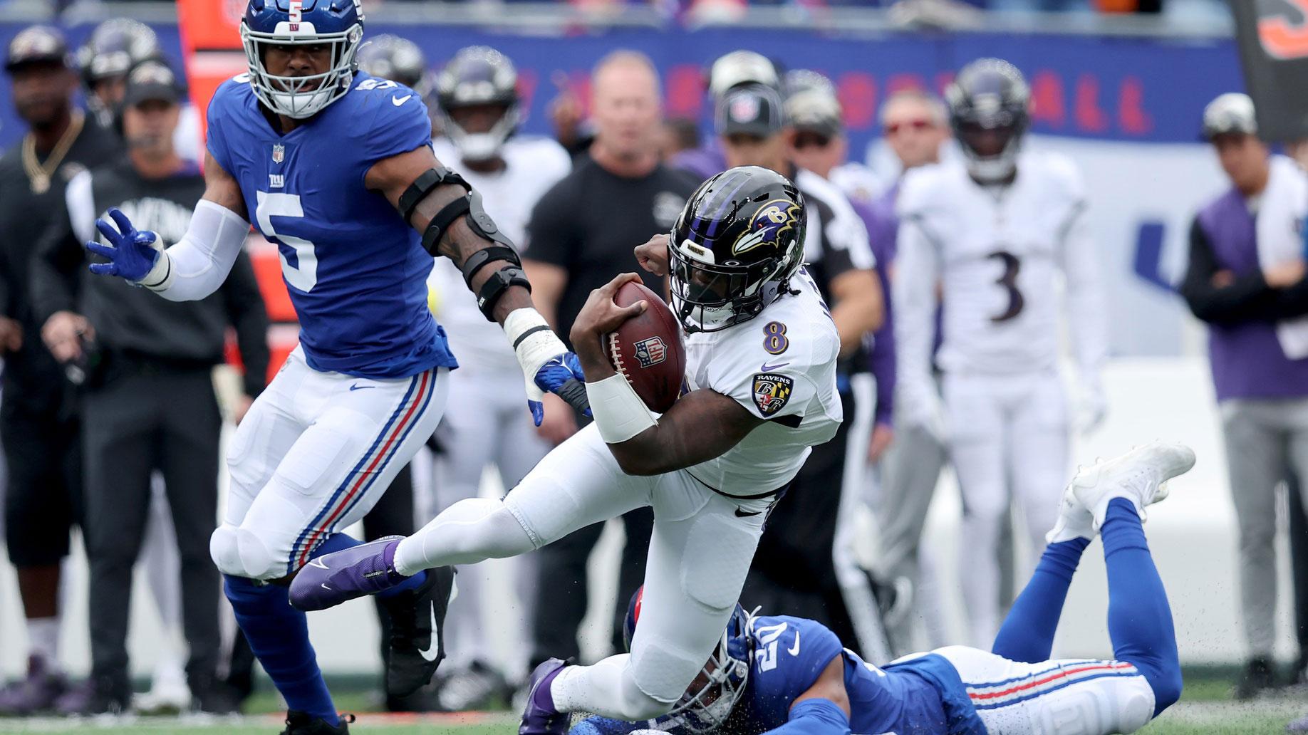Oct 16, 2022; East Rutherford, New Jersey, USA; Baltimore Ravens quarterback Lamar Jackson (8) runs with the ball against New York Giants safety Julian Love (20) and defensive end Kayvon Thibodeaux (5) during the first quarter at MetLife Stadium. / Brad Penner-USA TODAY Sports