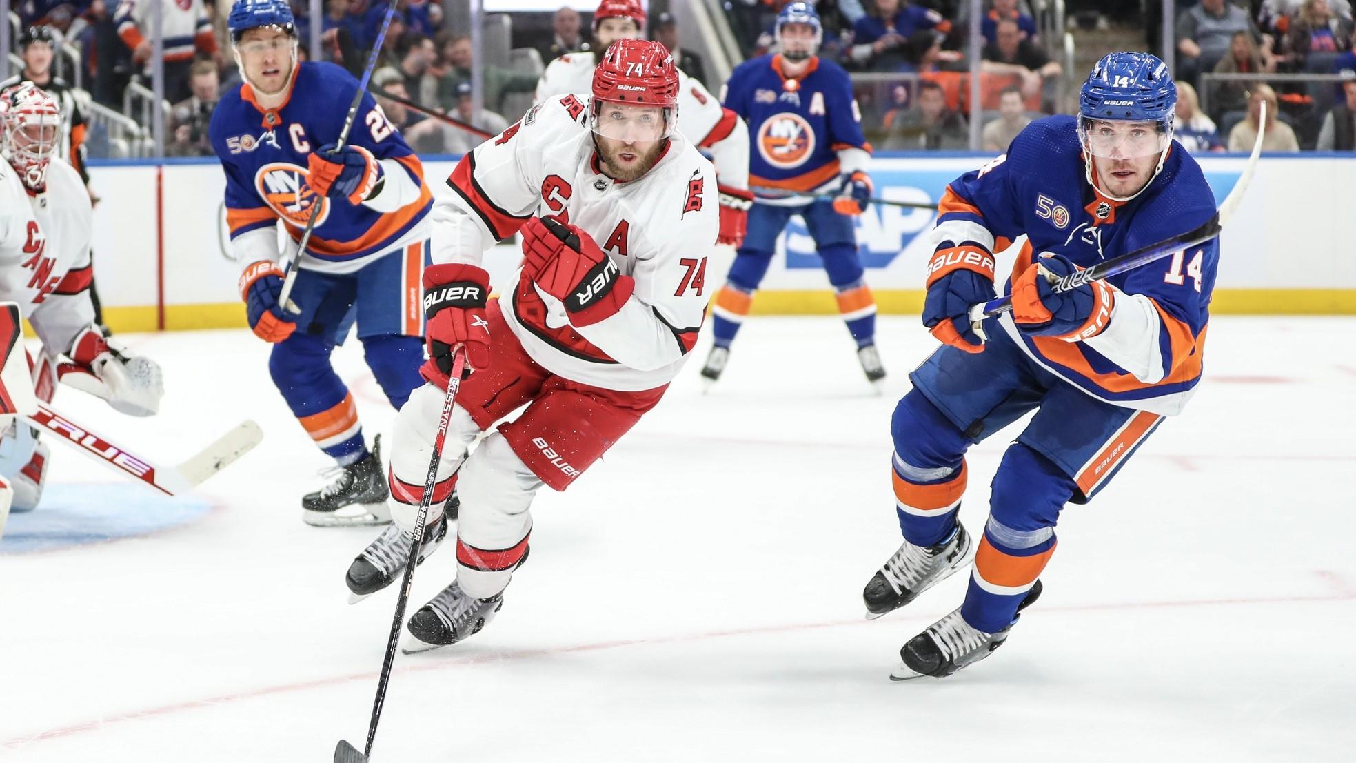 Apr 28, 2023; Elmont, New York, USA; Carolina Hurricanes defenseman Jaccob Slavin (74) and New York Islanders center Bo Horvat (14) chase the puck in game six of the first round of the 2023 Stanley Cup Playoffs at UBS Arena. / Wendell Cruz-USA TODAY Sports