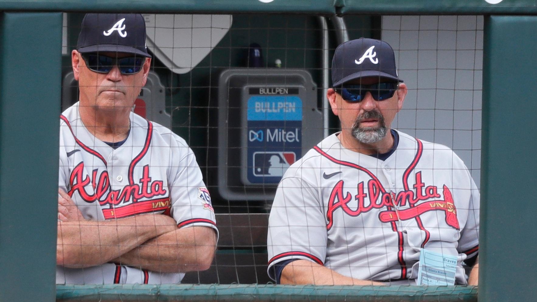Jun 26, 2021; Cincinnati, Ohio, USA; Atlanta Braves manager Brian Snitker (left) and bench coach Walt Weiss (right) watch from the dugout during a game with the Cincinnati Reds at Great American Ball Park. / David Kohl-USA TODAY Sports