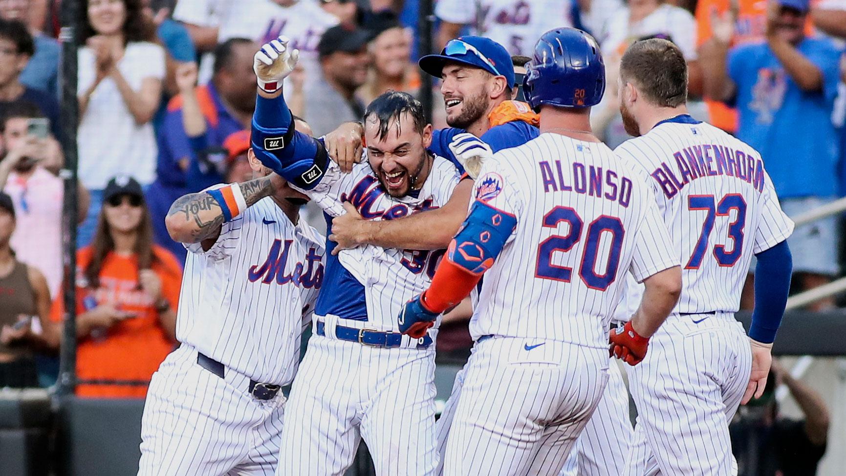 Jun 26, 2021; New York City, New York, USA; New York Mets right fielder Michael Conforto (30) is mobbed by teammates after hitting a sacrifice fly to defeat the Philadelphia Phillies at Citi Field. / Wendell Cruz-USA TODAY Sports