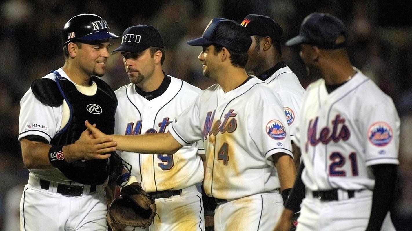 FLUSHING, UNITED STATES: New York Mets catcher Mike Piazza (L) is congratulated by teammates (2nd, L to R) Todd Ziele, Robin Ventura, Armando Benitez and Bobby Jones after the Mets beat the Atlanta Braves 3-2 behind an eighth inning 2-run home run by Piazza 21 September, 2001 at Shea Stadium in New York City. Security was high and the signs of patriotism everywhere as the two teams played the first baseball game in New York since the terrorist attack on the World Trade Center twin towers 11 September. / MATT CAMPBELL/AFP via Getty Images