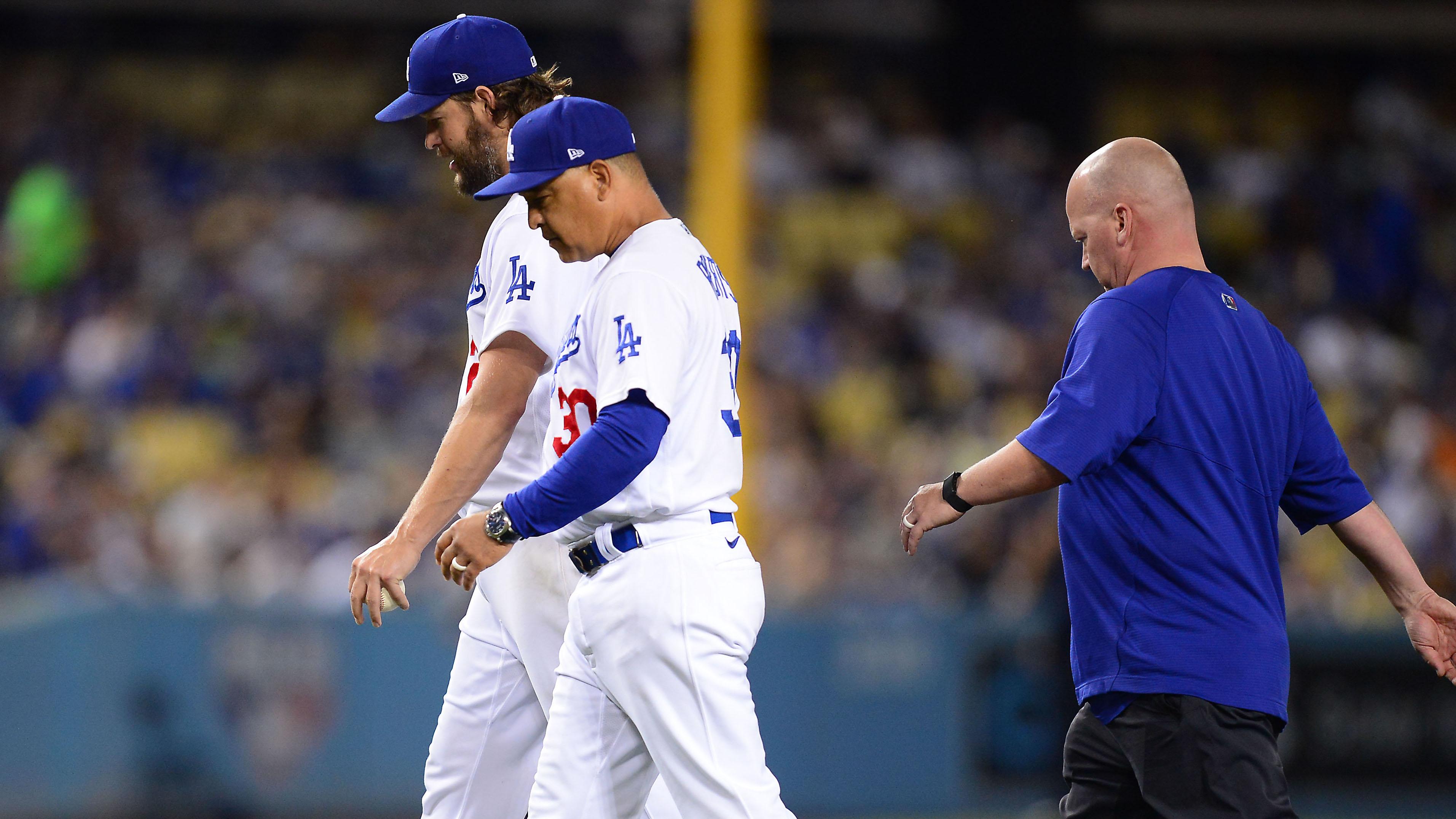 Los Angeles Dodgers starting pitcher Clayton Kershaw (22) leaves the game with manager Dave Roberts (30) and trainer Neil Rampe during the second inning against the Milwaukee Brewers at Dodger Stadium. / Gary A. Vasquez-USA TODAY Sports