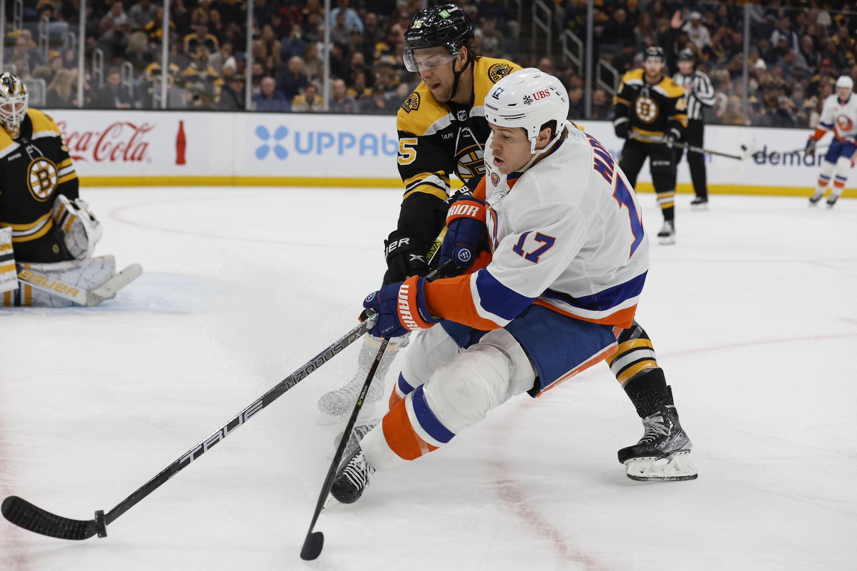 New York Islanders left wing Matt Martin (17) and Boston Bruins defenseman Brandon Carlo (25) battle for a loose puck during the second period at TD Garden. / Winslow Townson-USA TODAY Sports