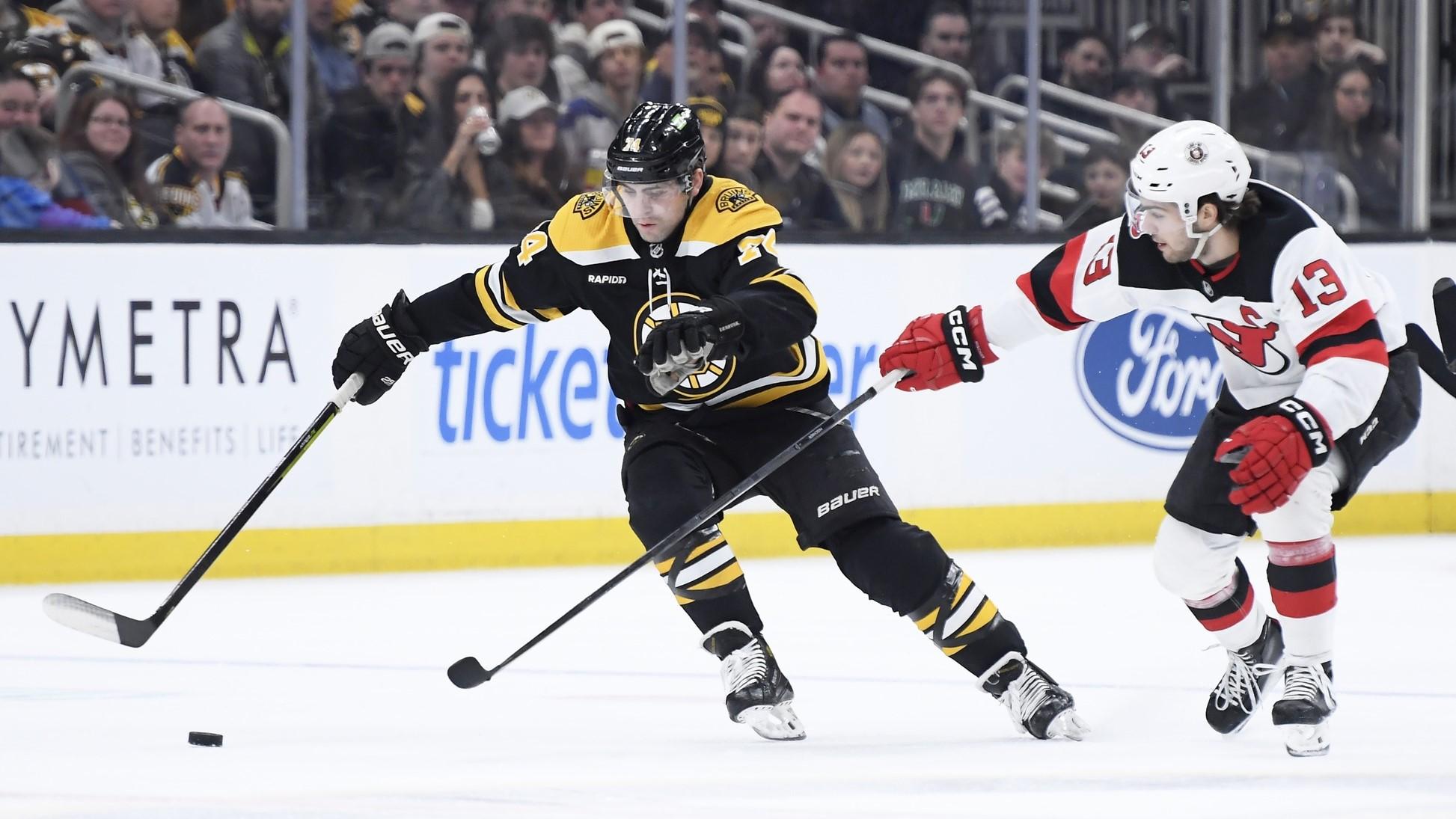 Apr 8, 2023; Boston, Massachusetts, USA; New Jersey Devils center Nico Hischier (13) tries to poke the puck away from Boston Bruins left wing Jake DeBrusk (74) during the first period at TD Garden. / Bob DeChiara-USA TODAY Sports