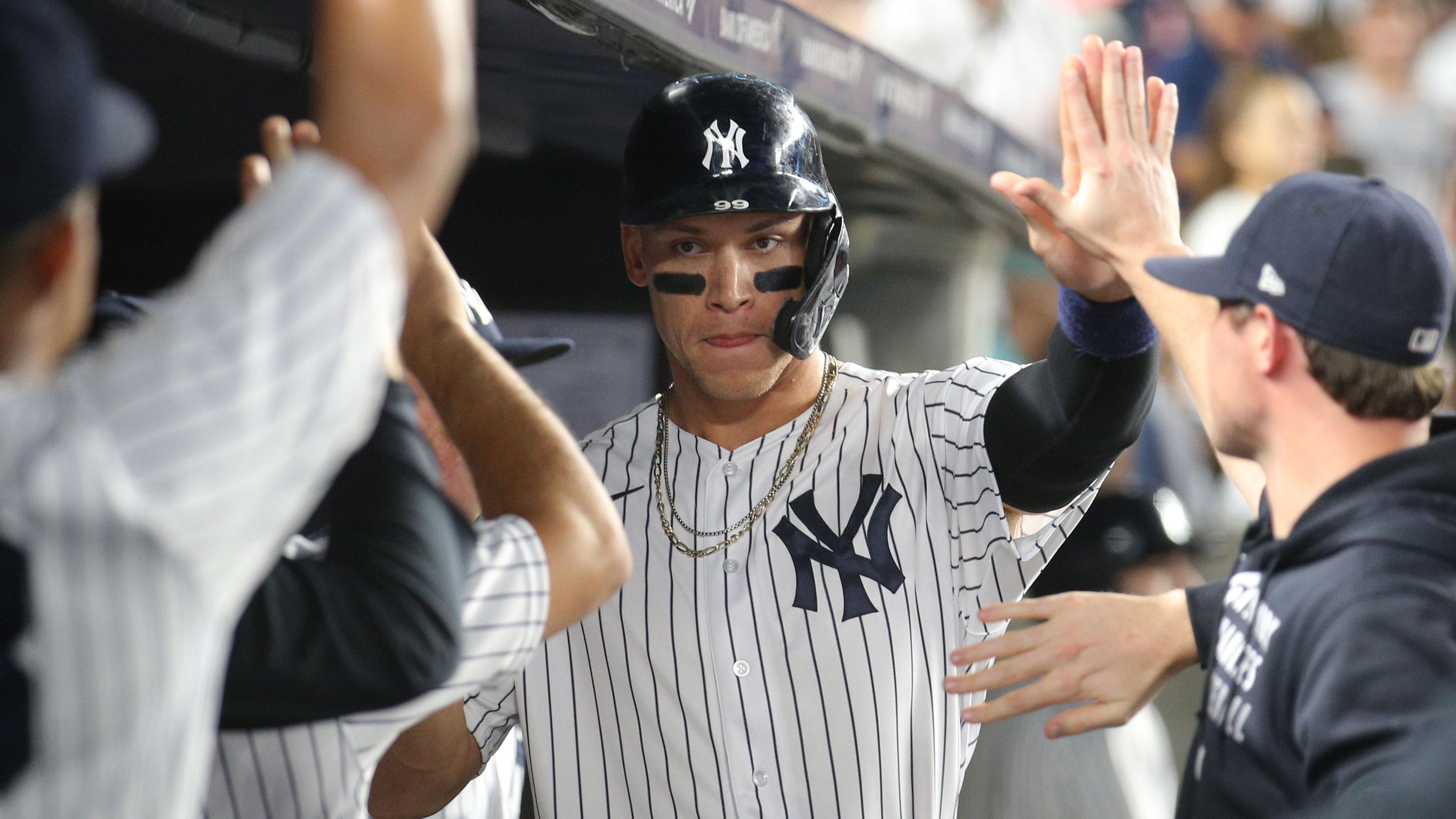 Sep 22, 2021; Bronx, New York, USA; New York Yankees designated hitter Aaron Judge (99) celebrates in the dugout with teammates after scoring from third base against the Texas Rangers on a wild pitch during the sixth inning at Yankee Stadium. / Brad Penner-USA TODAY Sports