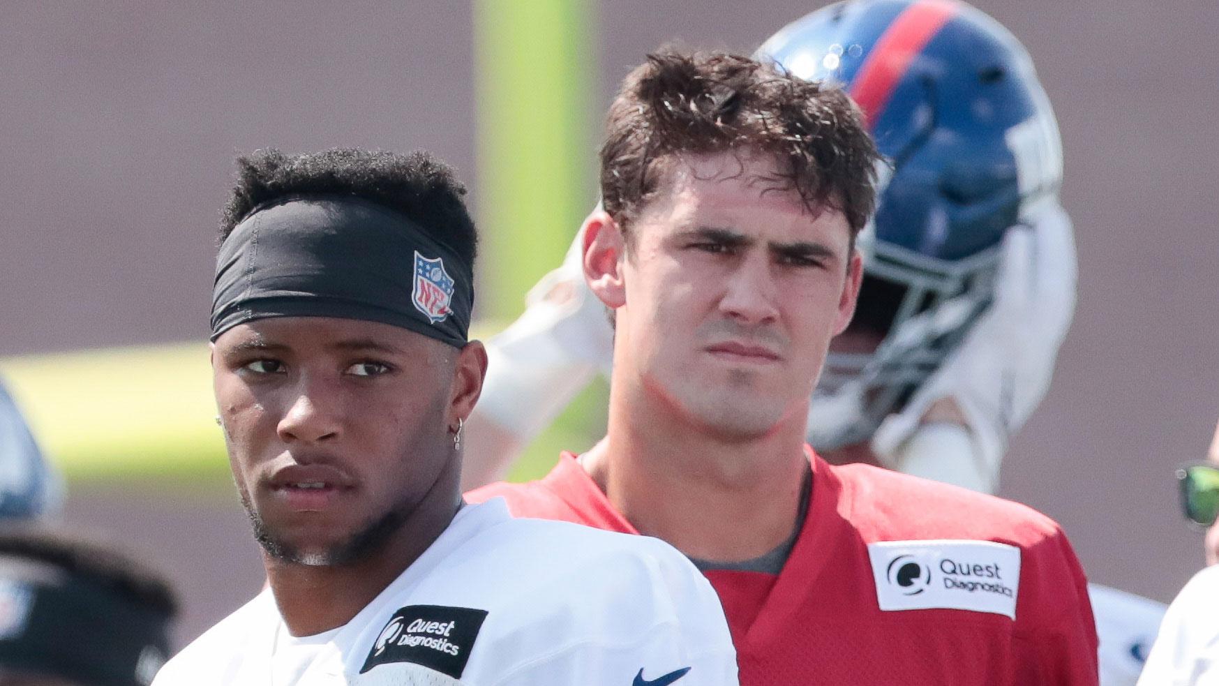 Jul 25, 2019; East Rutherford, NJ, USA; New York Giants running back Saquon Barkley (26) and quarterback Daniel Jones (8) look on during the first day of training camp at Quest Diagnostics Training Center. / Vincent Carchietta-USA TODAY Sports