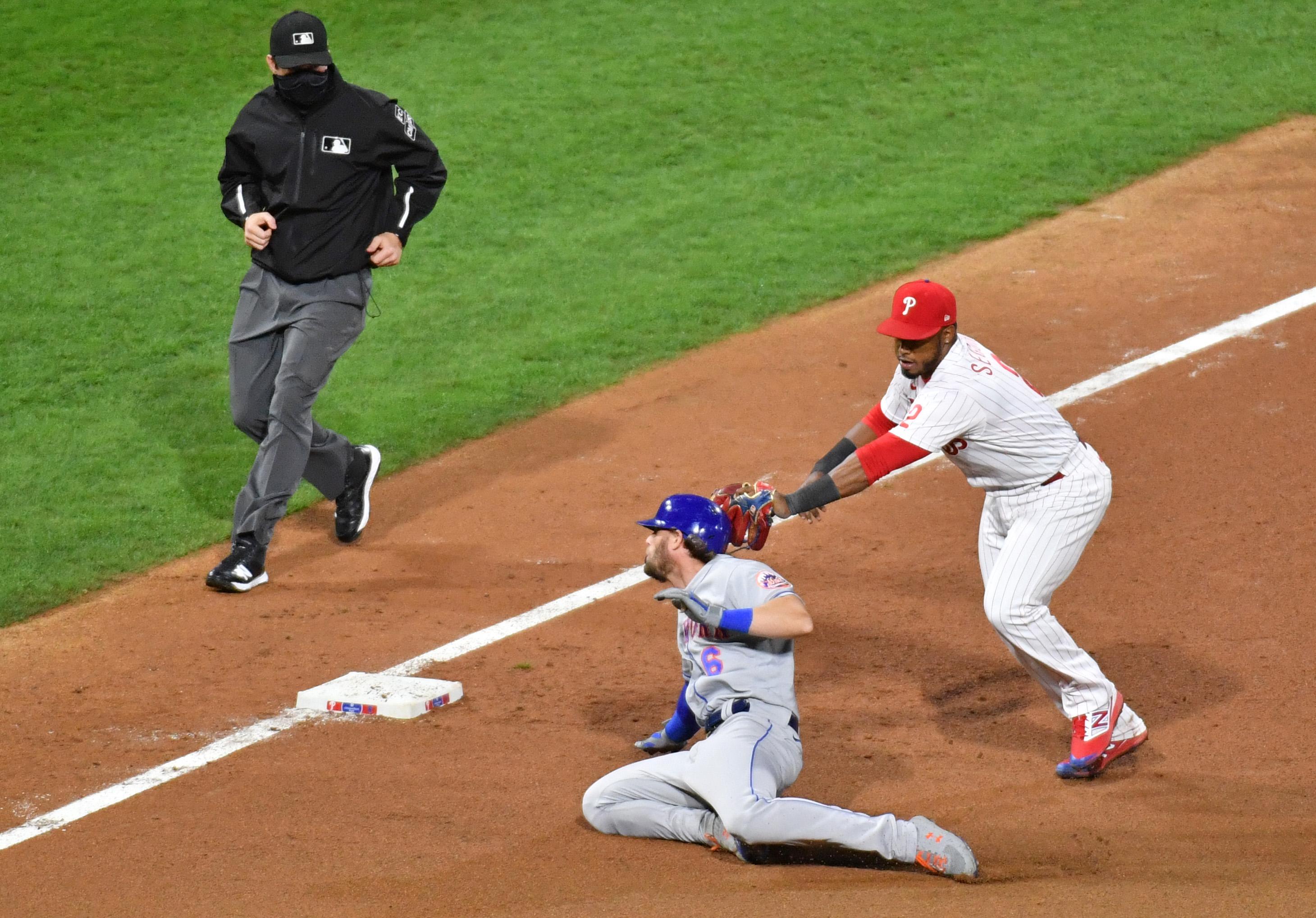 Jeff McNeil is tagged out at third base / USA Today
