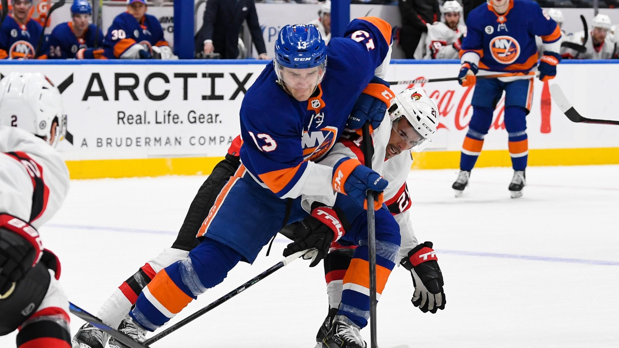 Mar 22, 2022; Elmont, New York, USA; New York Islanders center Mathew Barzal (13) skates with the puck defended by Ottawa Senators right wing Mathieu Joseph (21) during the second period at UBS Arena. / Dennis Schneidler-USA TODAY Sports