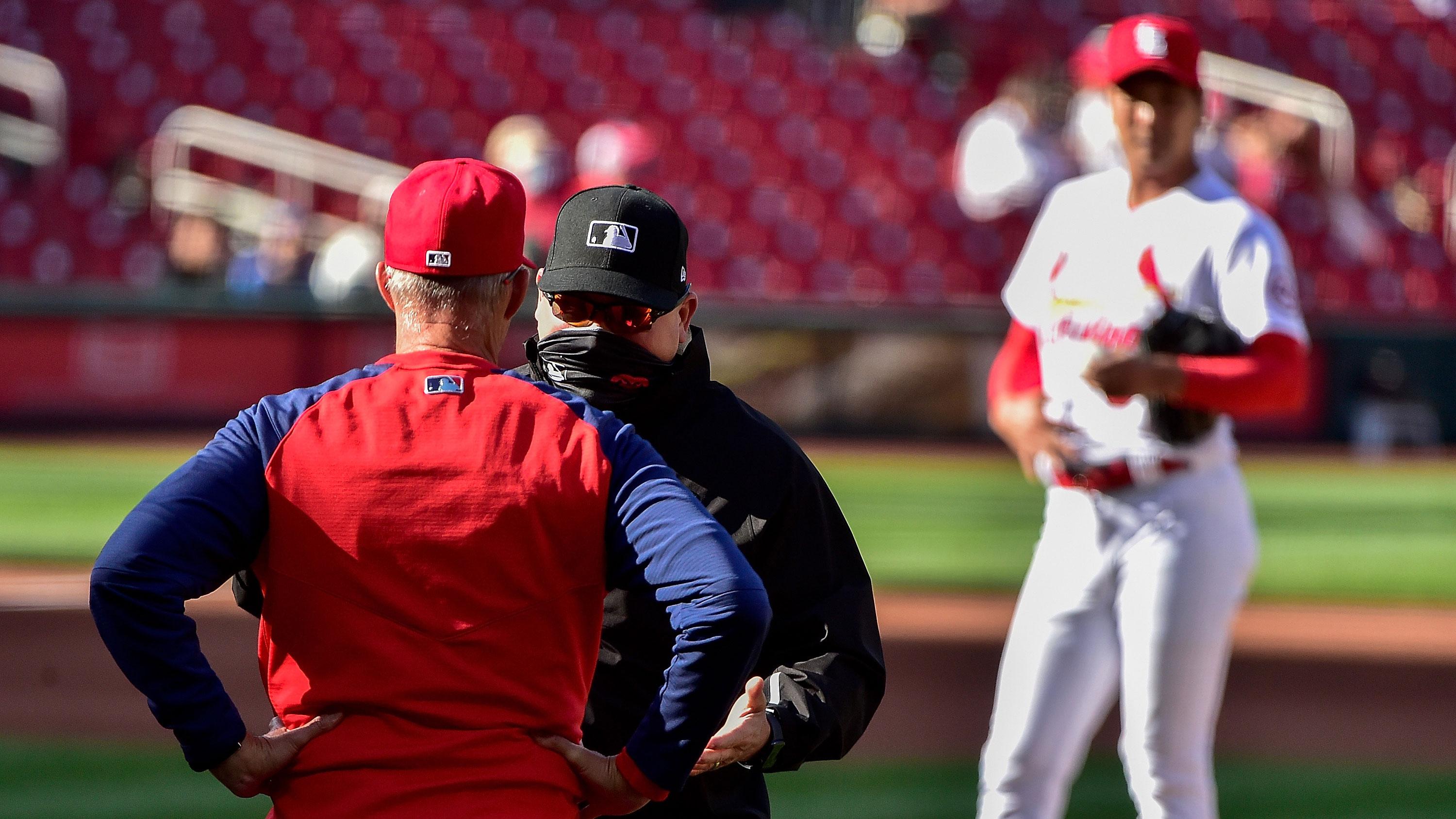 May 5, 2021; St. Louis, Missouri, USA; St. Louis Cardinals pitching coach Mike Maddux (31) is stopped by umpire Mark Carlson (6) as he walks out to the mound to talk with starting pitcher Kwang Hyun Kim (33) during the fourth inning against the New York Mets in game one of a doubleheader at Busch Stadium. / Jeff Curry-USA TODAY Sports