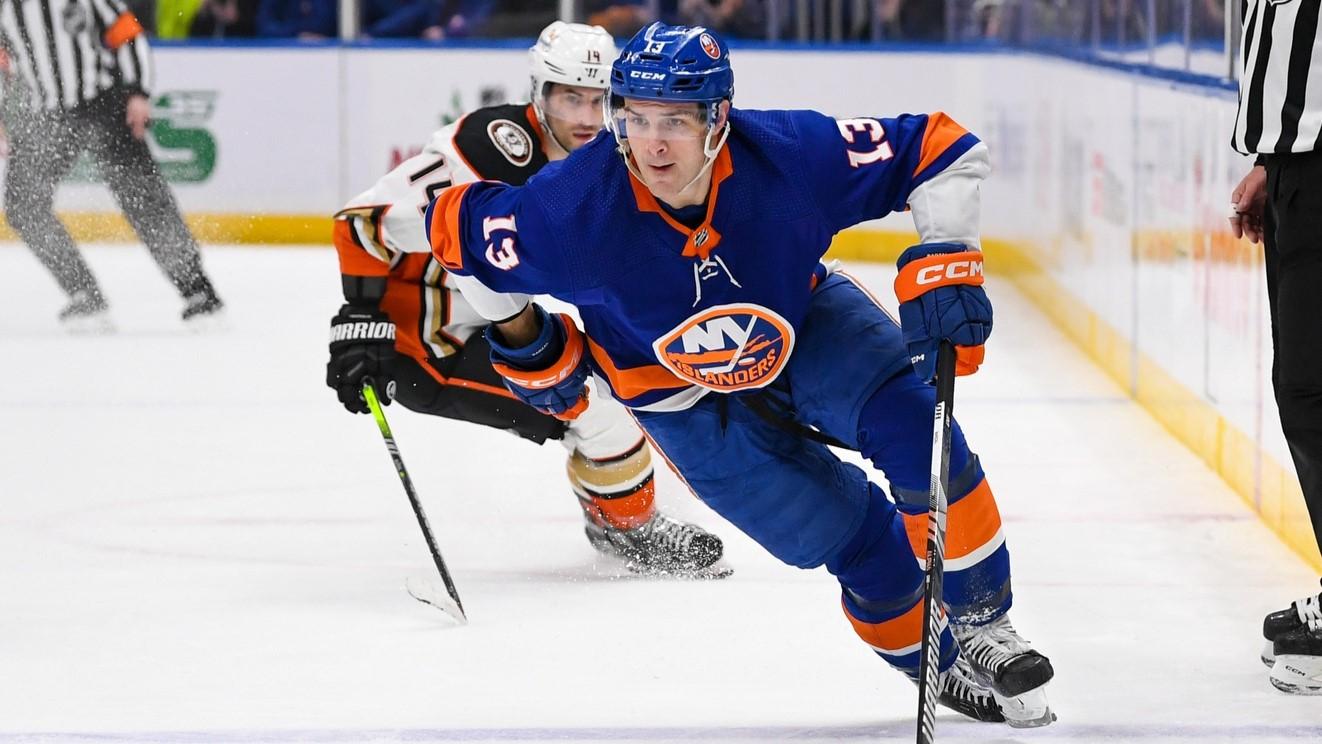 Dec 13, 2023; Elmont, New York, USA; New York Islanders center Mathew Barzal (13) shares with the puck against the Anaheim Ducks during the first period at UBS Arena. / Dennis Schneidler-USA TODAY Sports