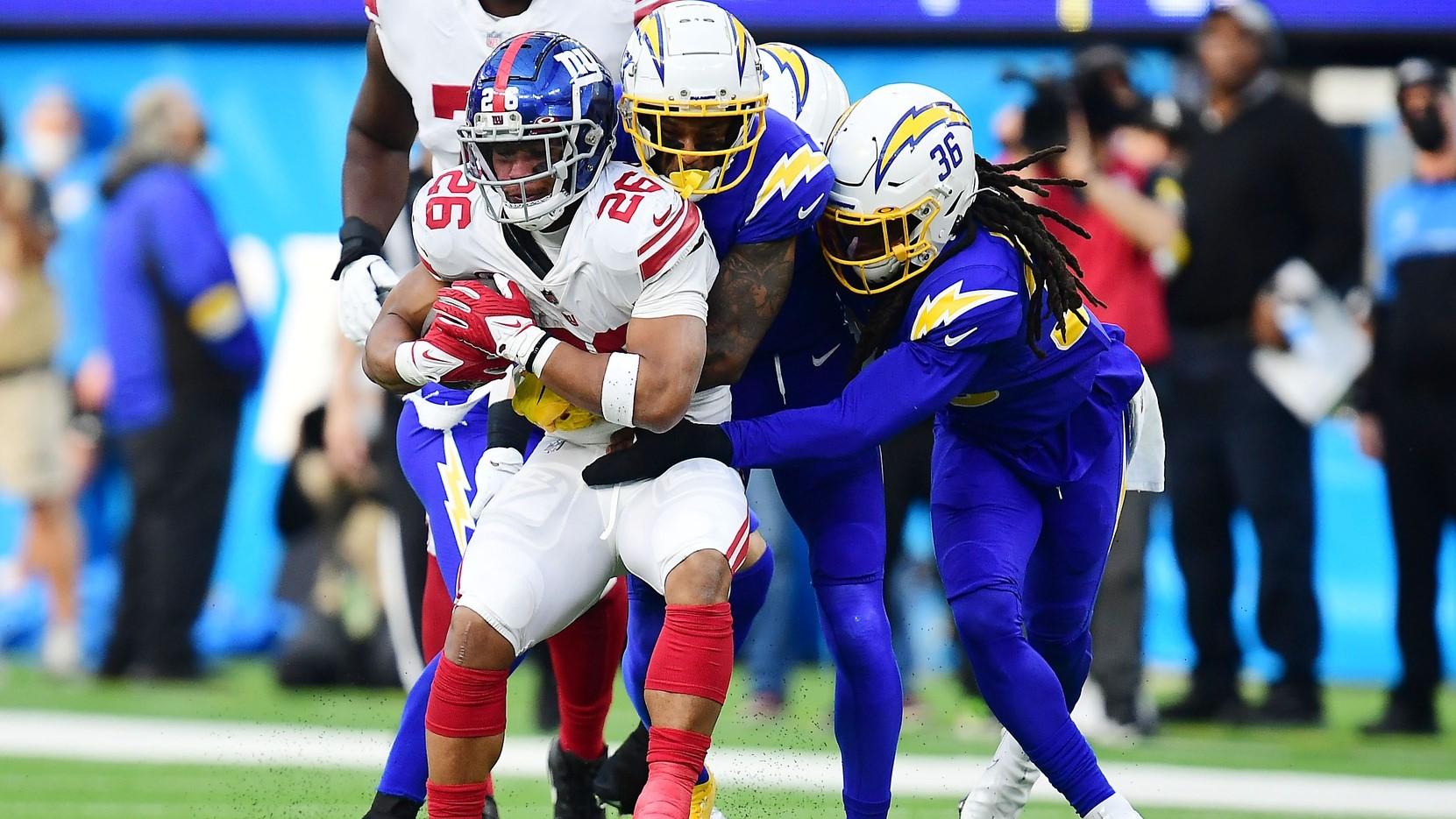 Dec 12, 2021; Inglewood, California, USA; New York Giants running back Saquon Barkley (26) is stopped by Los Angeles Chargers defensive back Trey Marshall (36) and the defense during the first half at SoFi Stadium. / Gary A. Vasquez-USA TODAY Sports